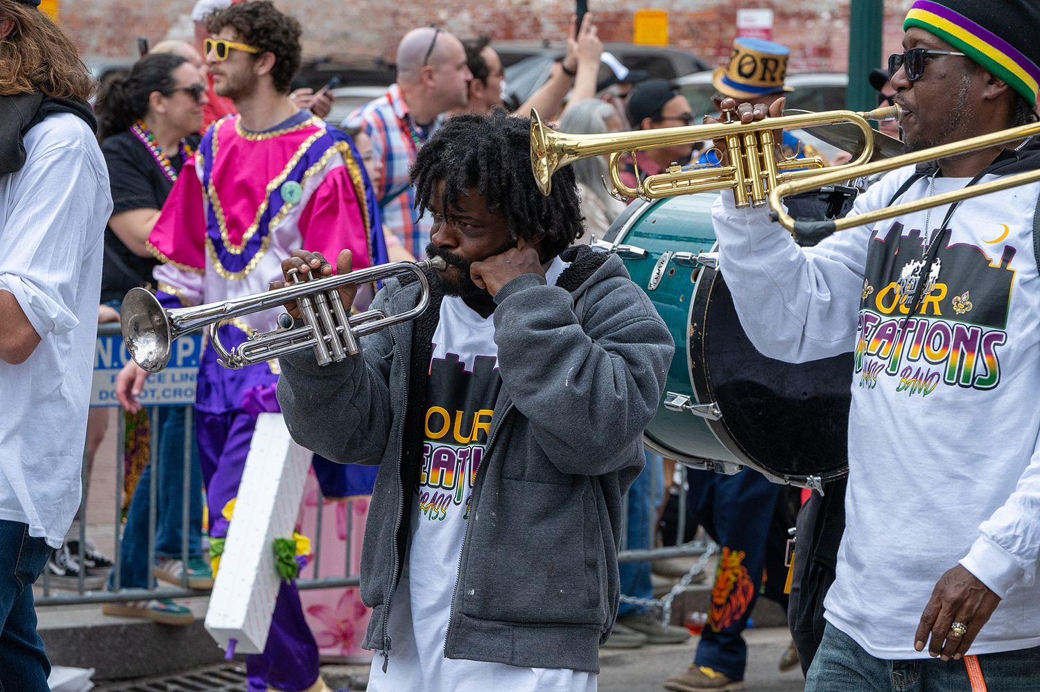 Musicians playing brass instruments during a lively street parade celebration.