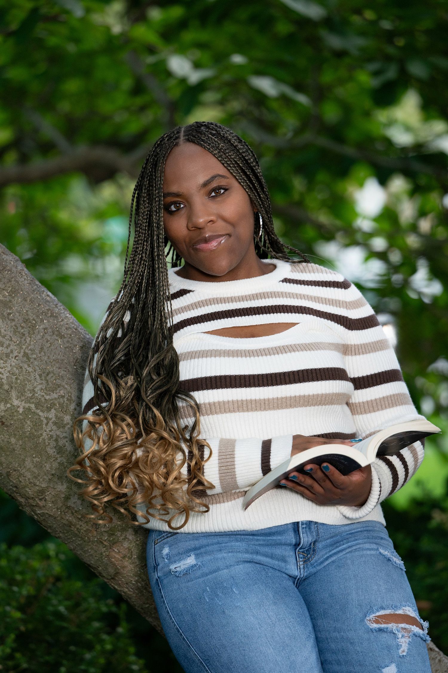 Casual fashion photography in natural outdoor setting with greenery.