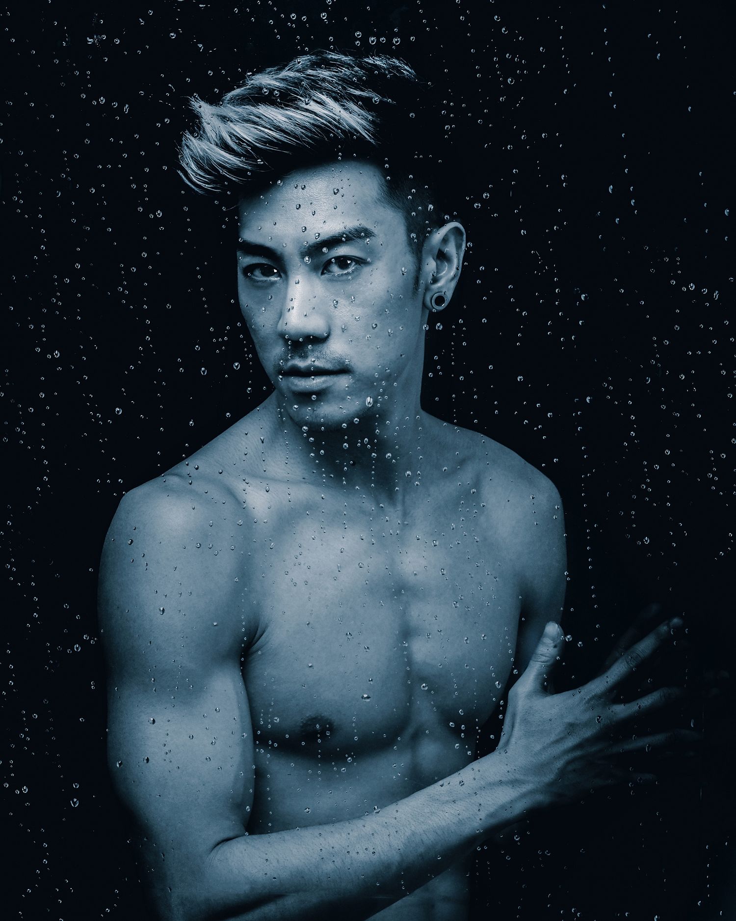 Artistic portrait with water droplets against dark background.
