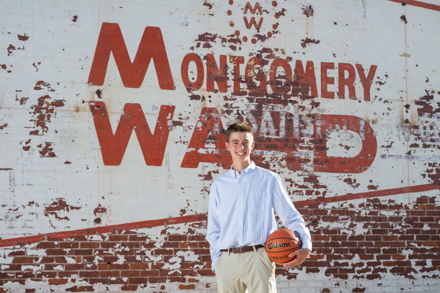 Distressed brick wall with faded red lettering and text.