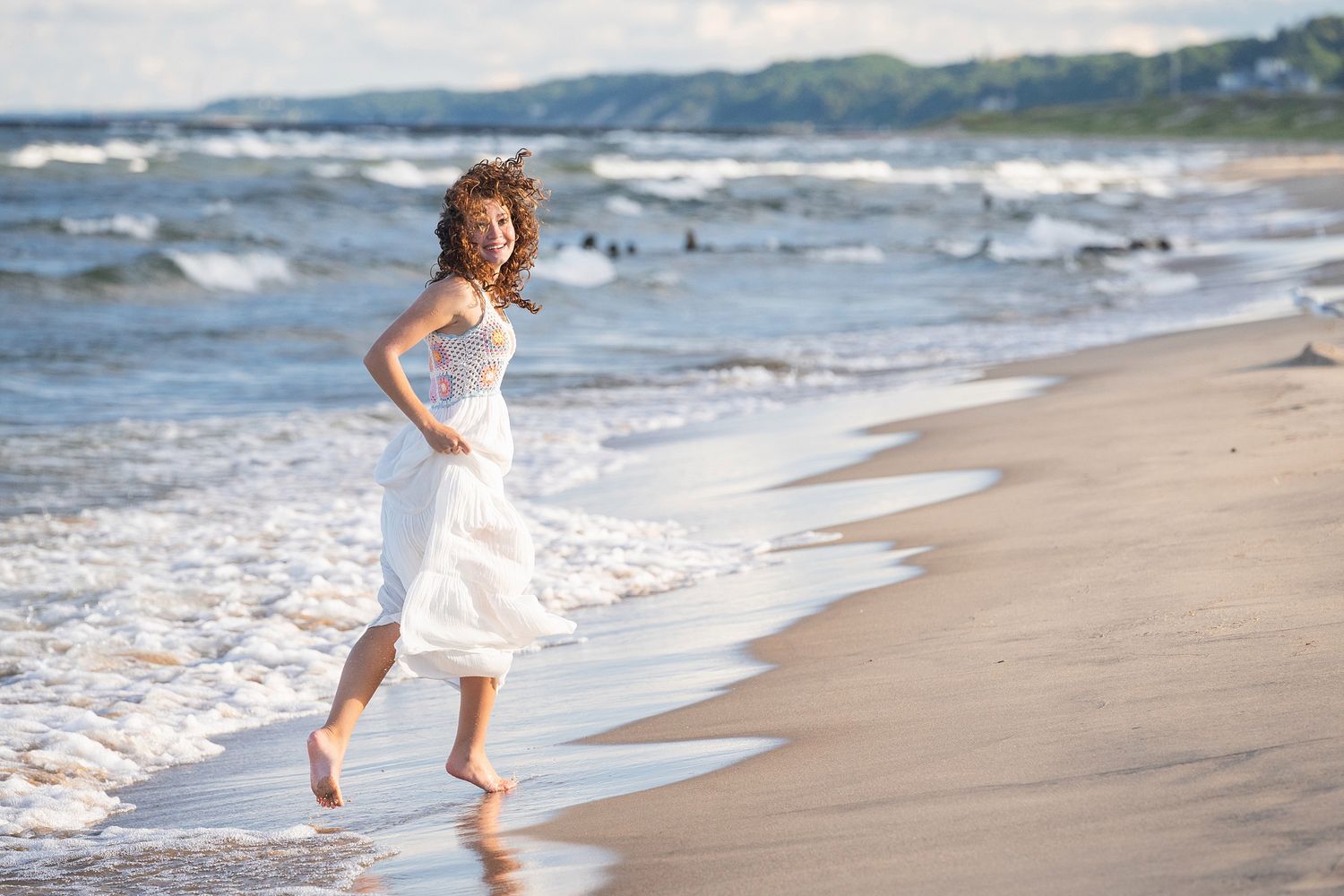 A carefree moment captured while running barefoot along the water's edge at the beach.