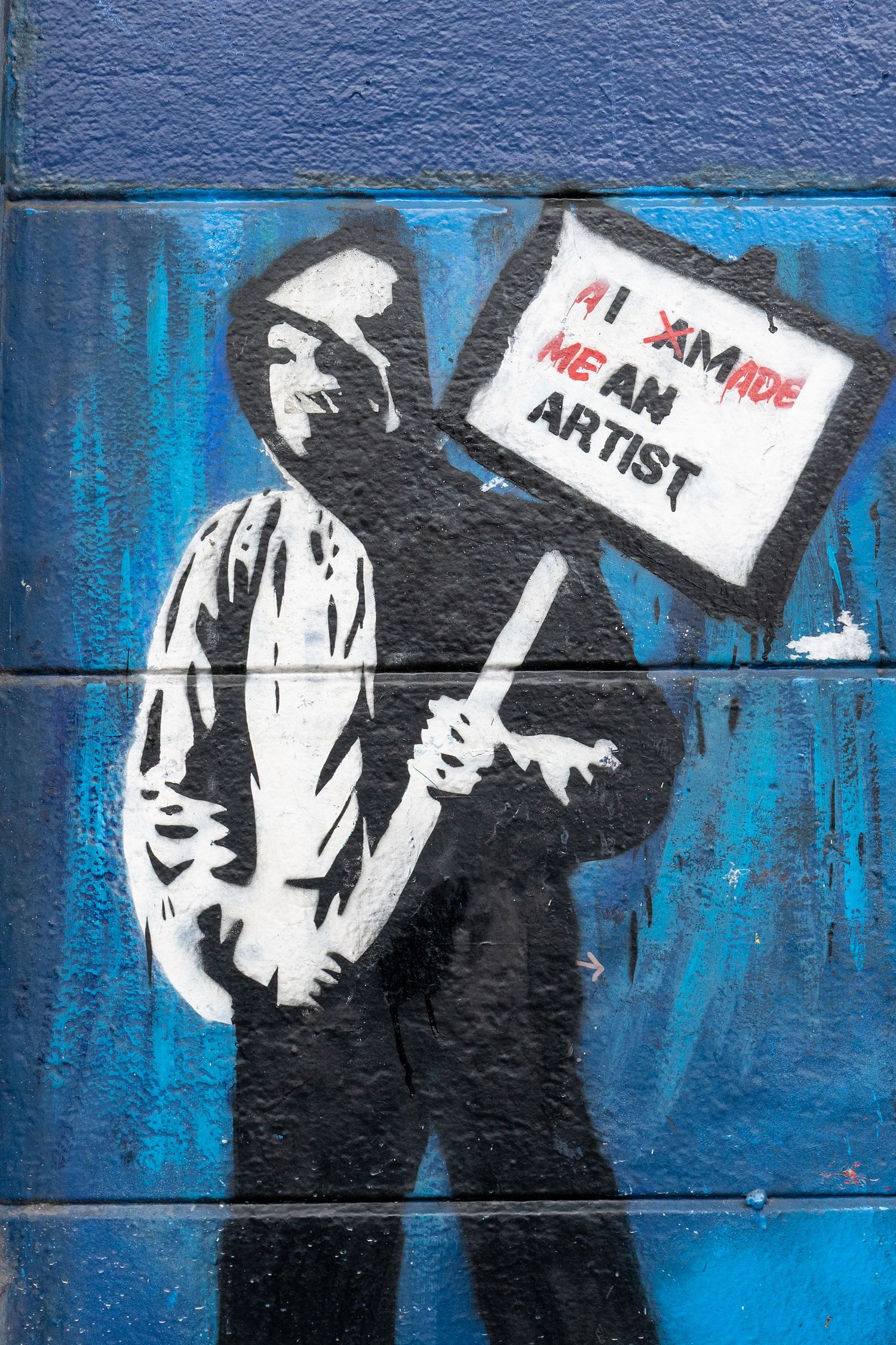 Street art mural on blue wall showing protest figures holding signs in black and white style.