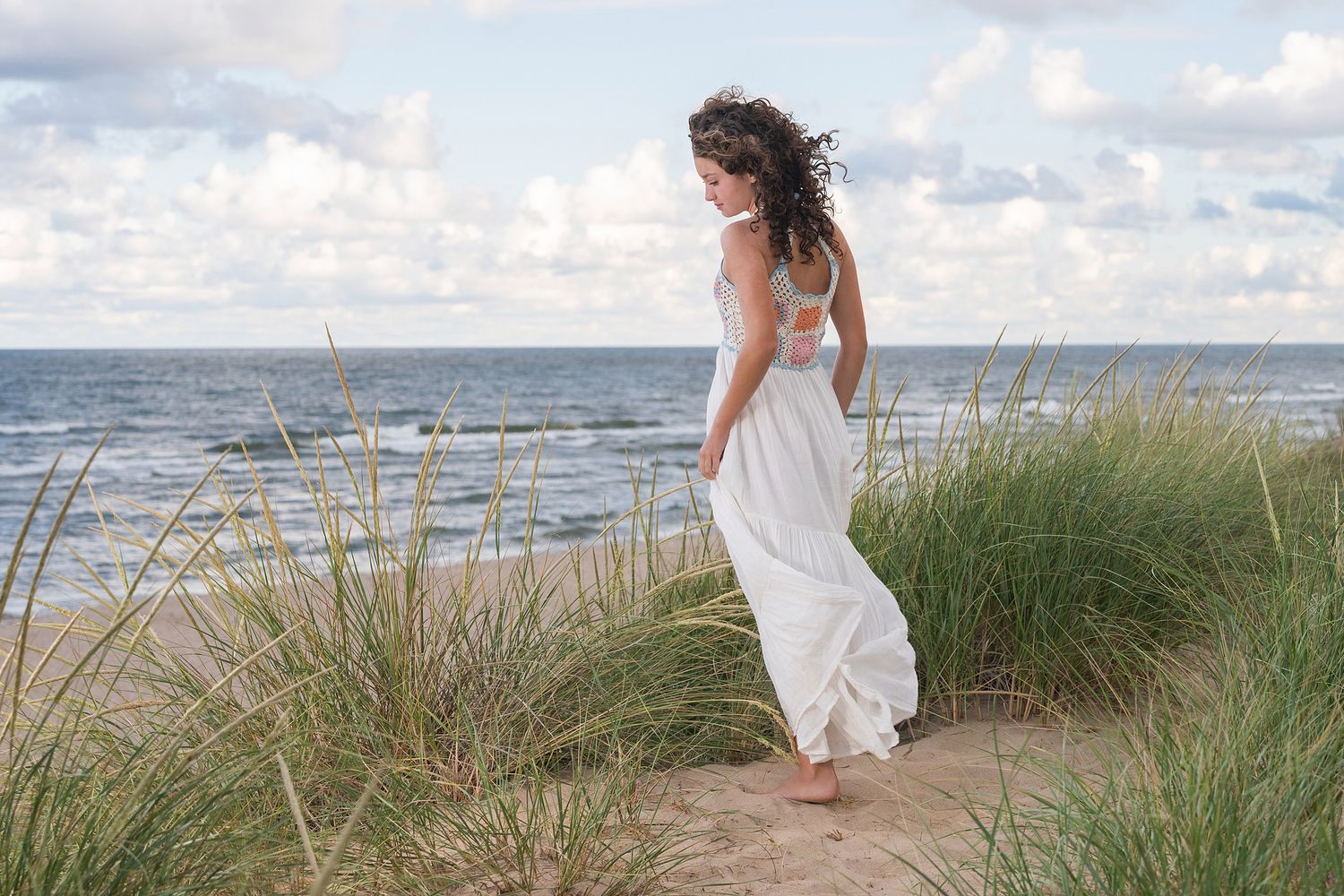 Beach photography sequence with flowing dress and natural dune grass.