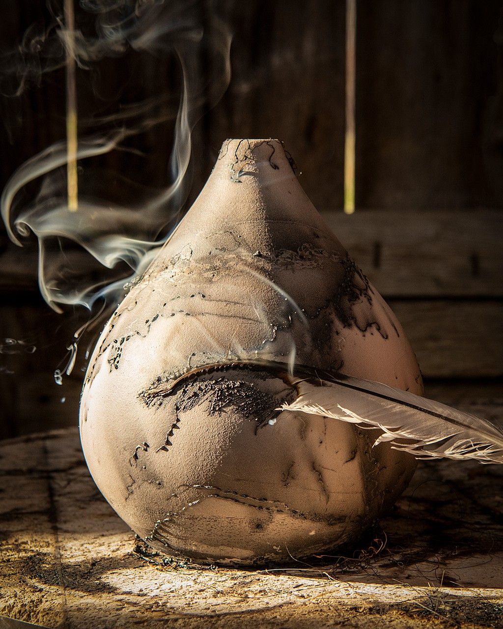 Artistic still life of clay pottery with smoke effects in dramatic lighting.