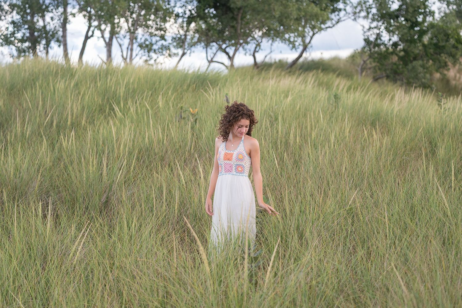 Natural outdoor portrait session in field with trees and grass.