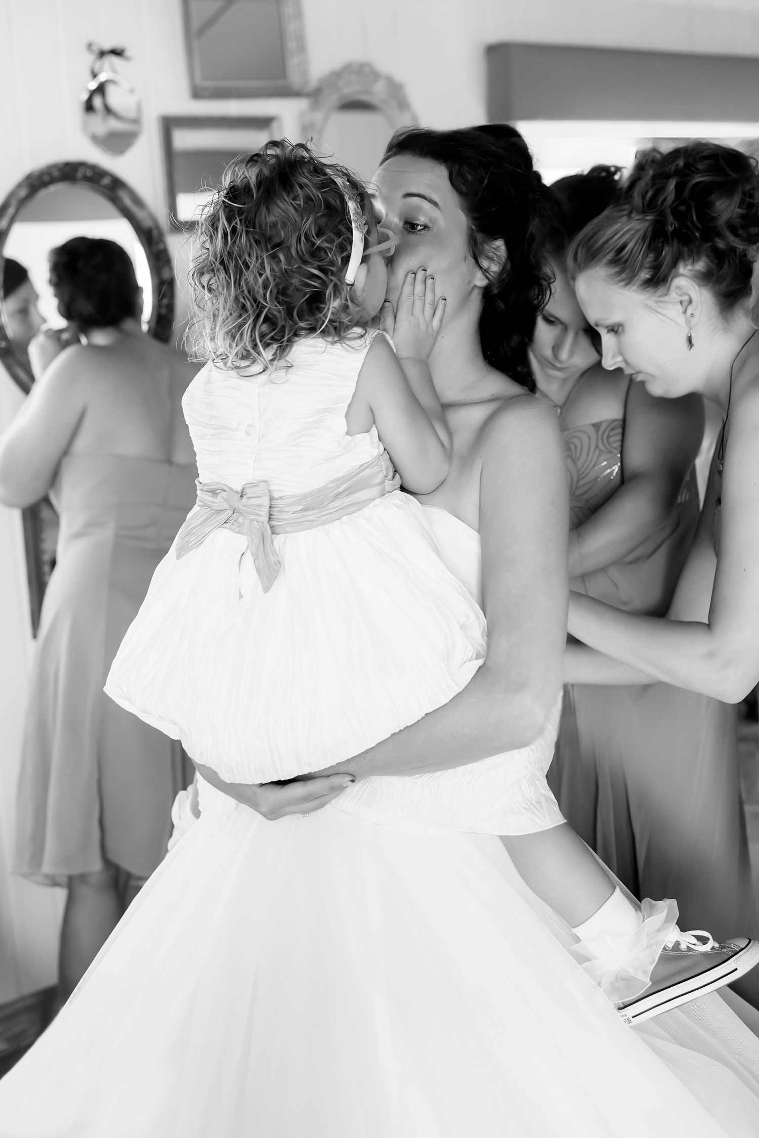 A tender black and white moment between a bride and small child during wedding preparations.