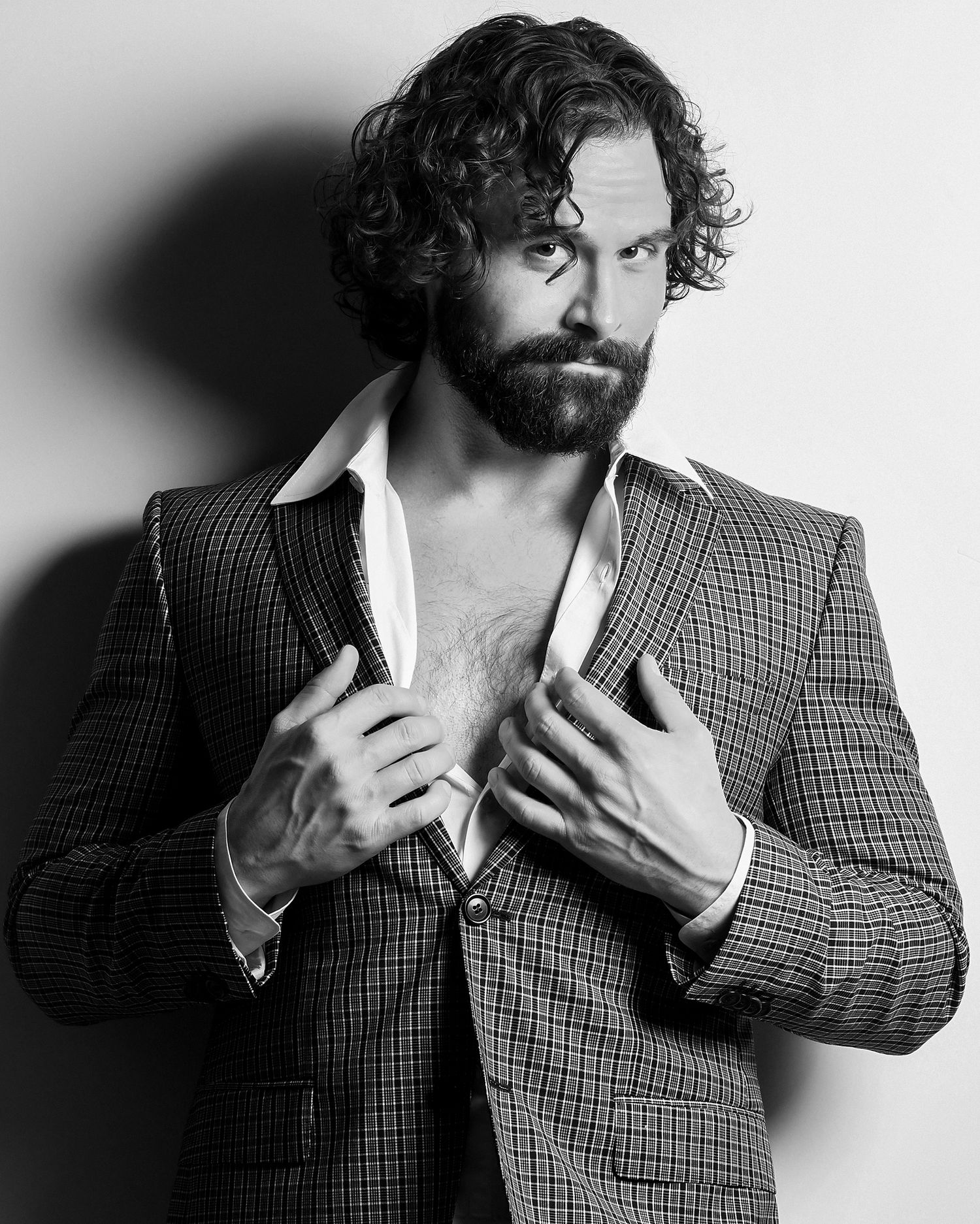 Black and white portrait series showing expressive poses in checkered blazer.
