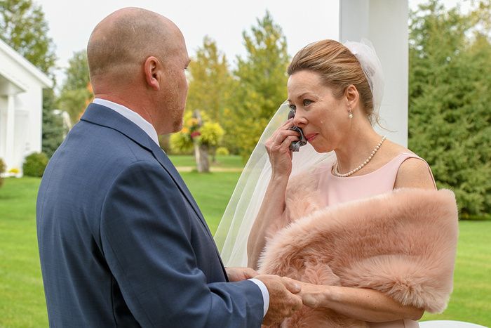 Emotional wedding moment shared between couple outdoors with pink shawl.