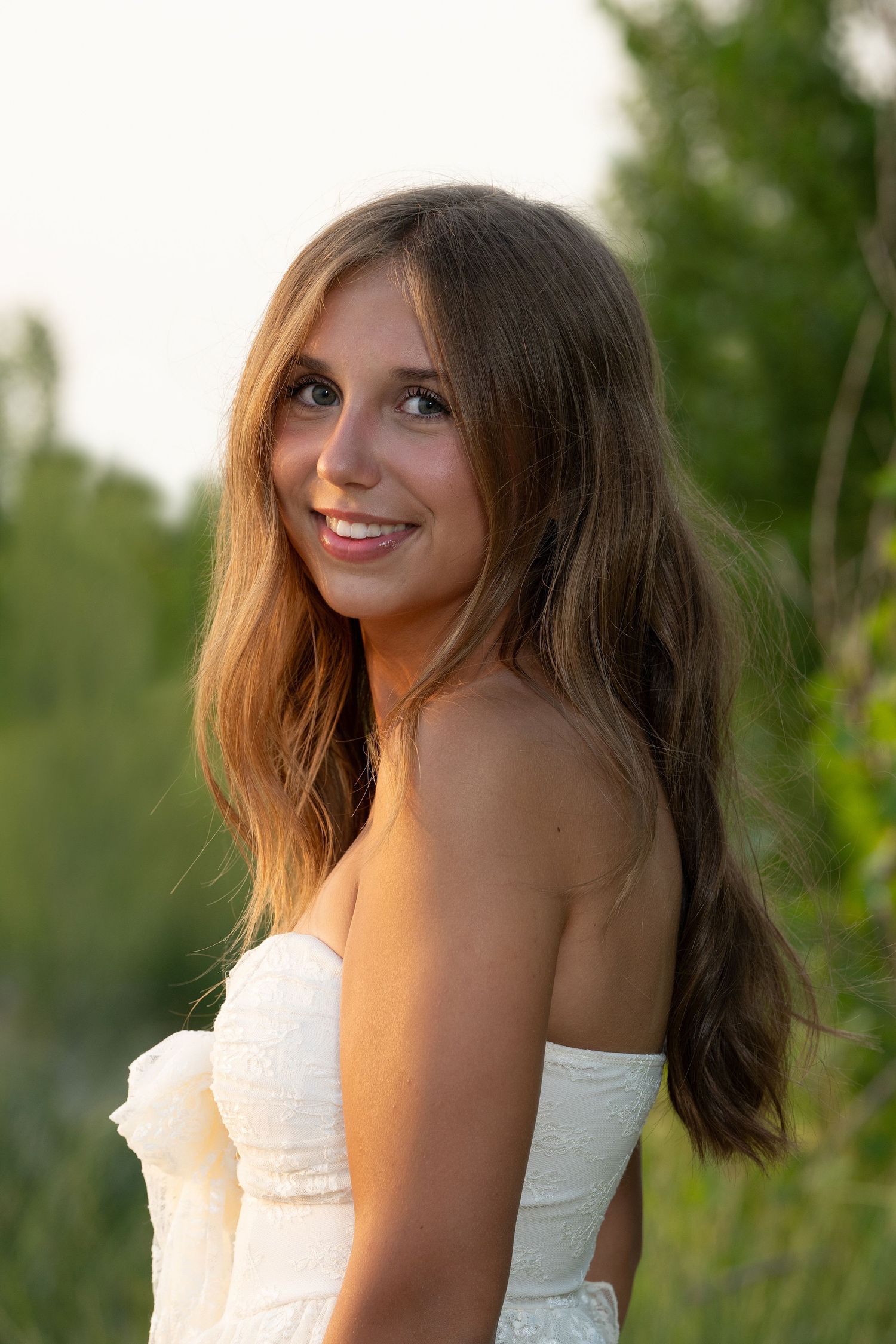 Sunset portrait session featuring a white summer dress against natural lighting.