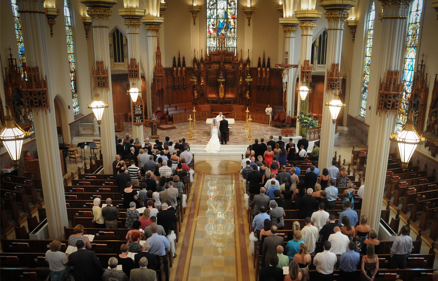 Traditional church wedding ceremony with guests seated in wooden pews.
