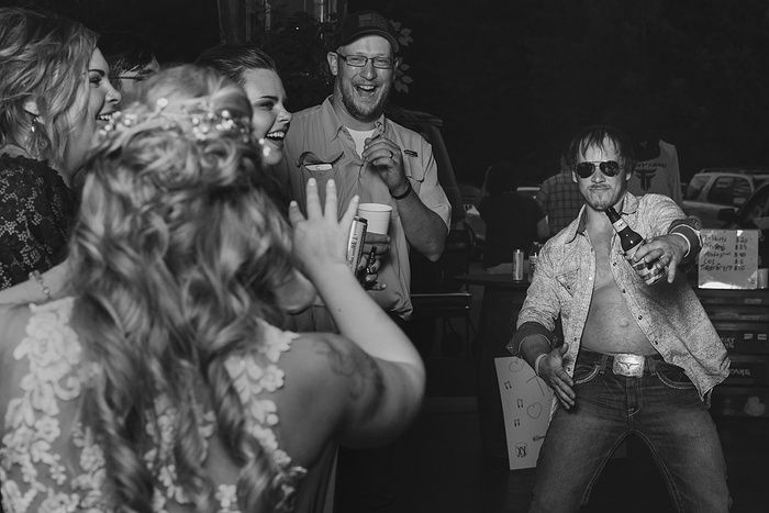 Black and white candid reception photo showing dancing and celebration.