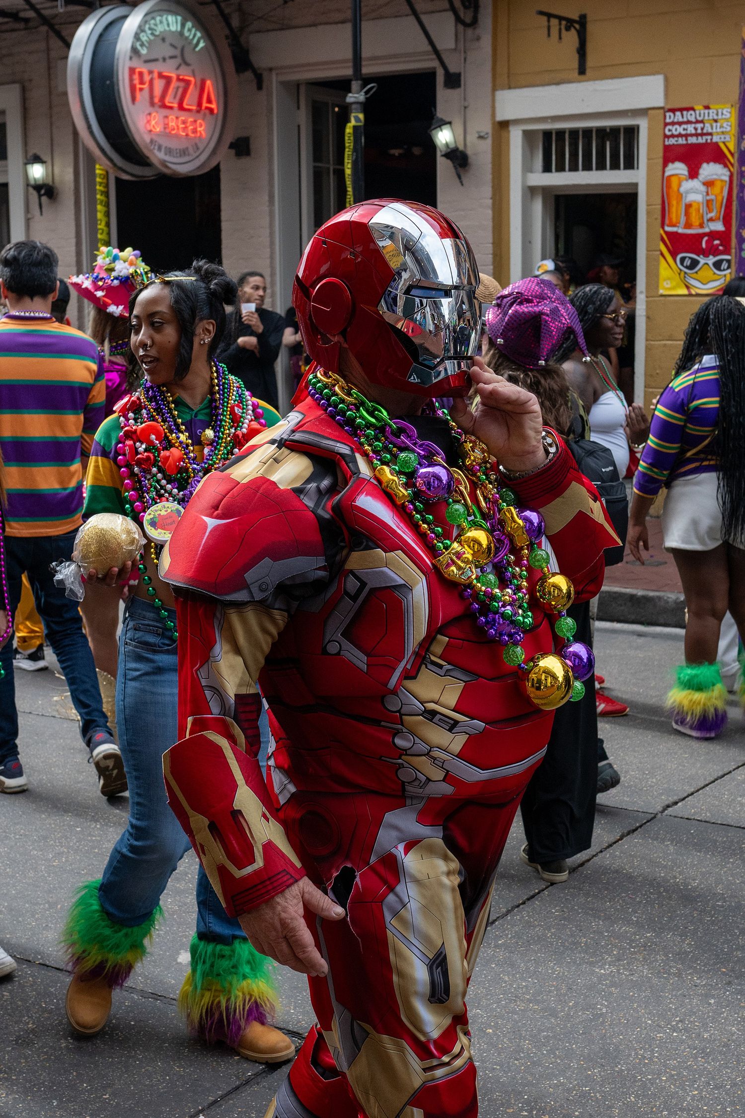 Parade participants in red costumes dance through the streets during Mardi Gras festivities.