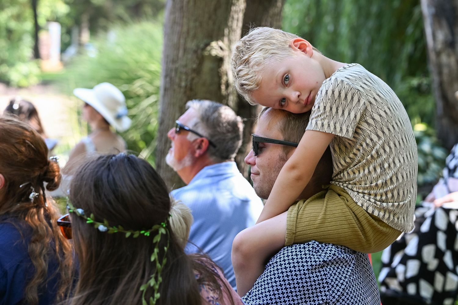 Guests watching and taking photos during an outdoor summer celebration.