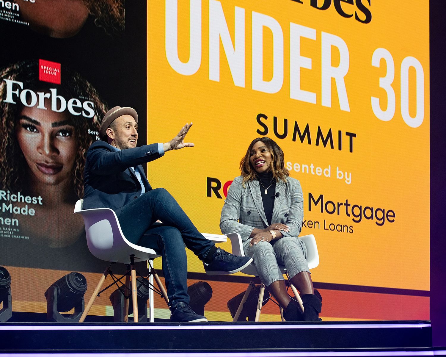 Panel discussion at Forbes Under 30 Summit with speakers on stage.