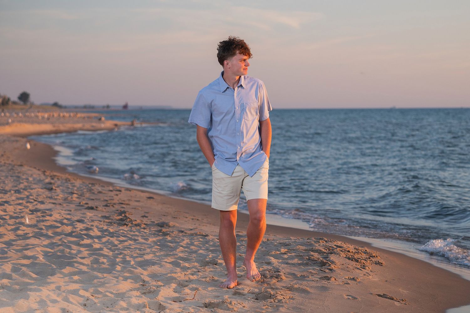 Peaceful beach scene with waves lapping at shore during golden hour.
