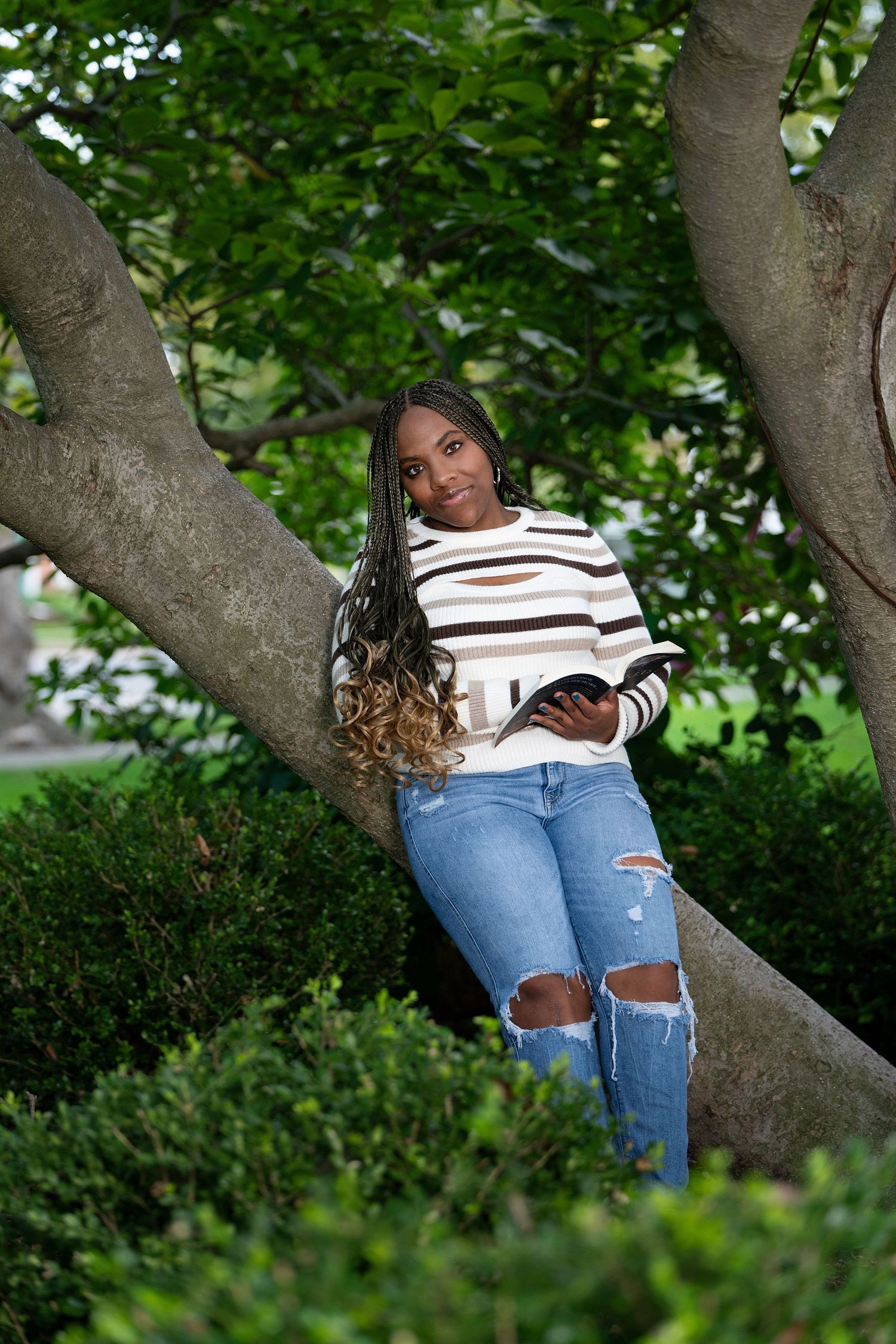 A casual outdoor photoshoot under a large tree with natural green foliage.