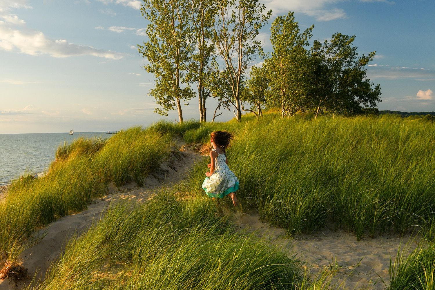 Scenic family portraits taken along a grassy beach dune path at sunset.