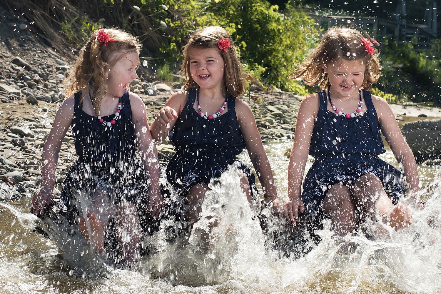 People splashing and playing in water creating dynamic spray patterns.