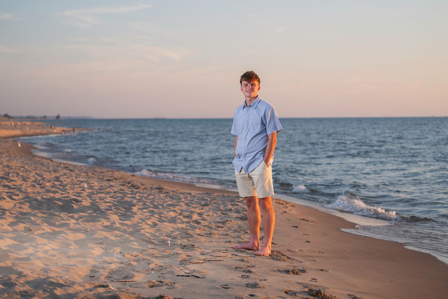 Scenic beach shoreline at sunset with gentle waves rolling onto sandy beach.
