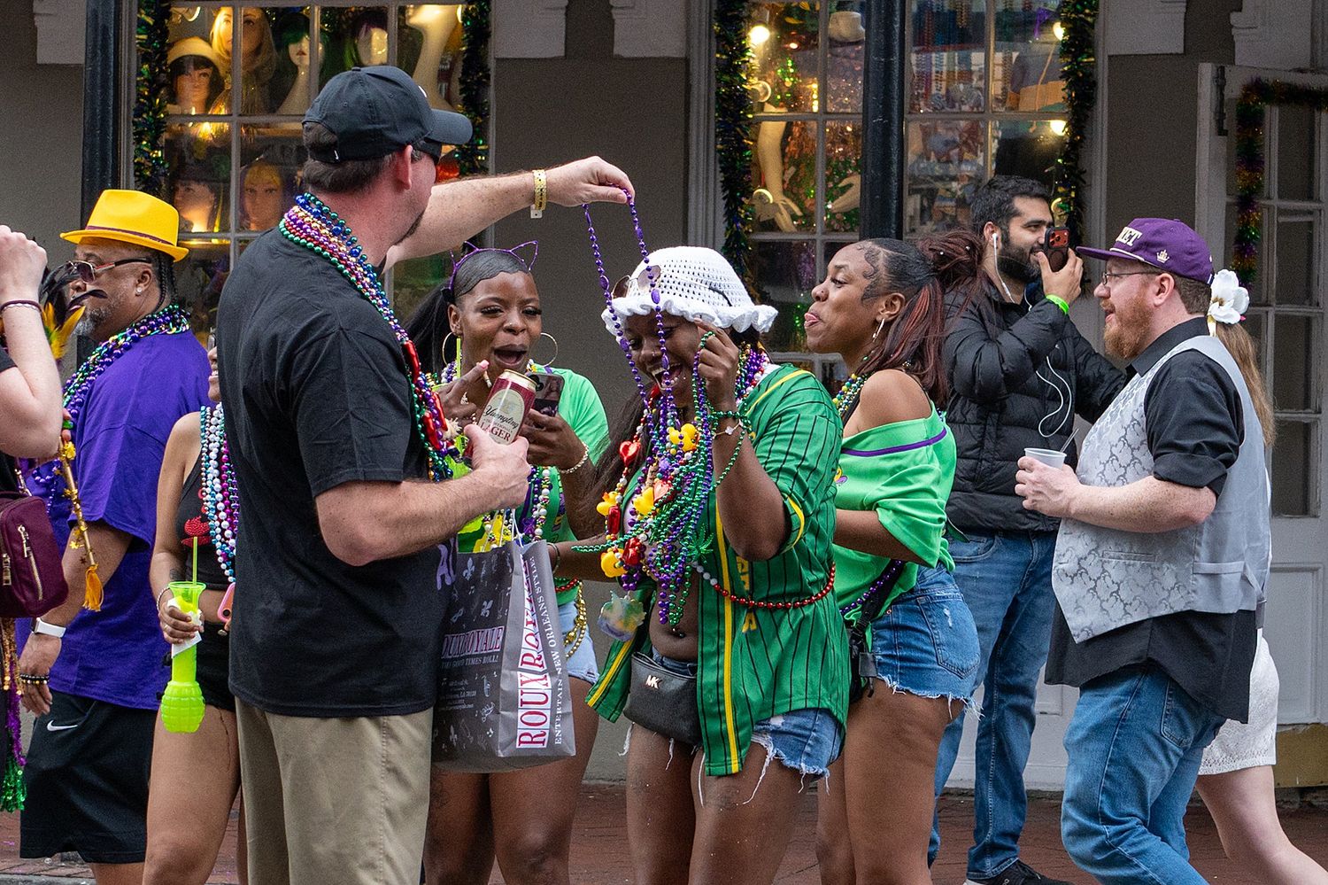 Street party atmosphere with crowds gathering during Mardi Gras celebrations.