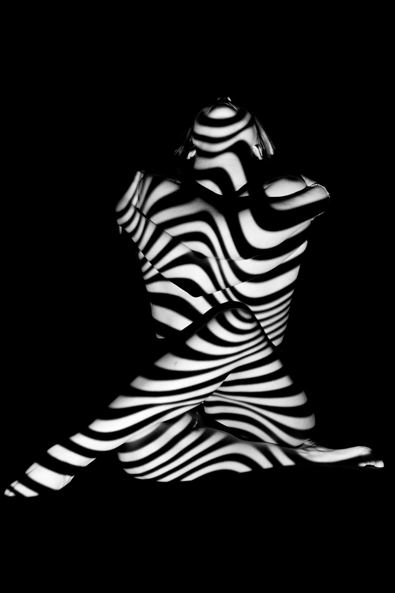 Abstract black and white striped light projection creating zebra pattern effect.