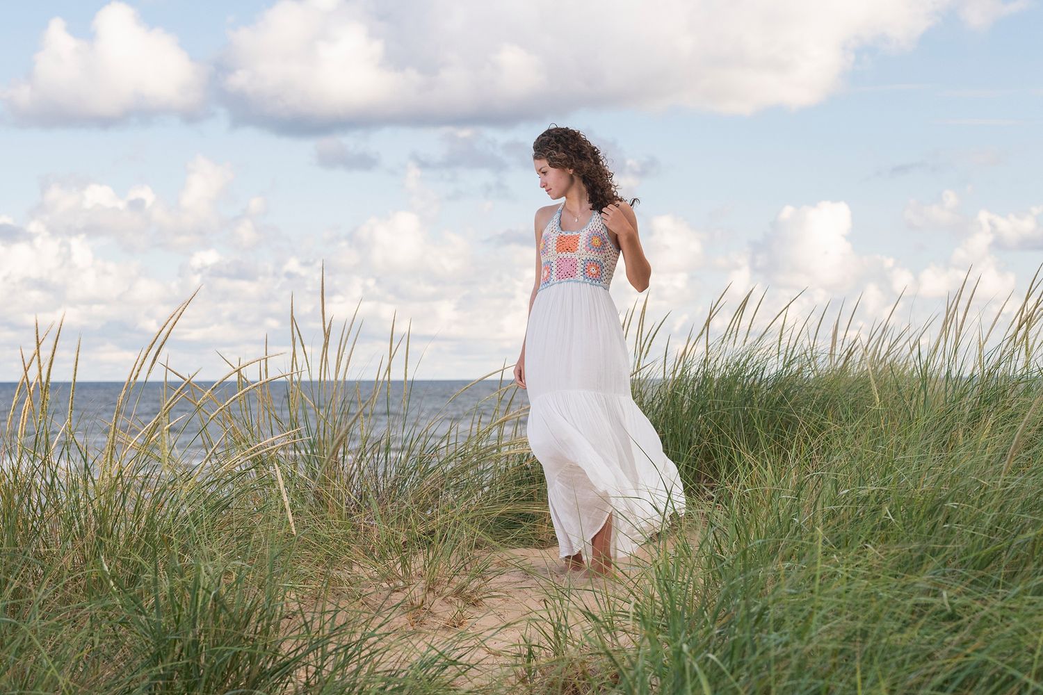 Seaside photo series with white dress against natural beach grass.