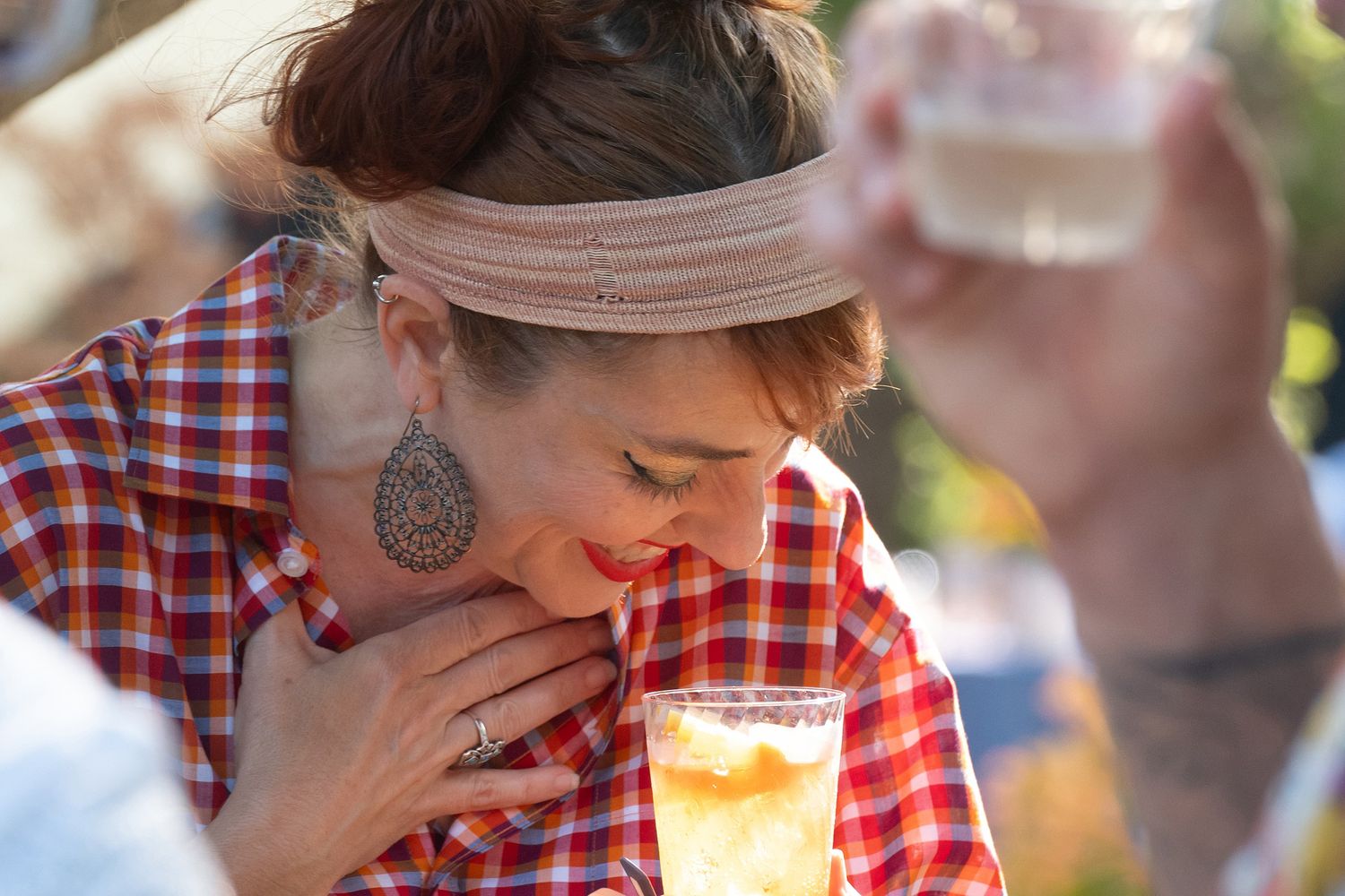 A couple in red plaid shirts sharing a romantic moment at an outdoor gathering.
