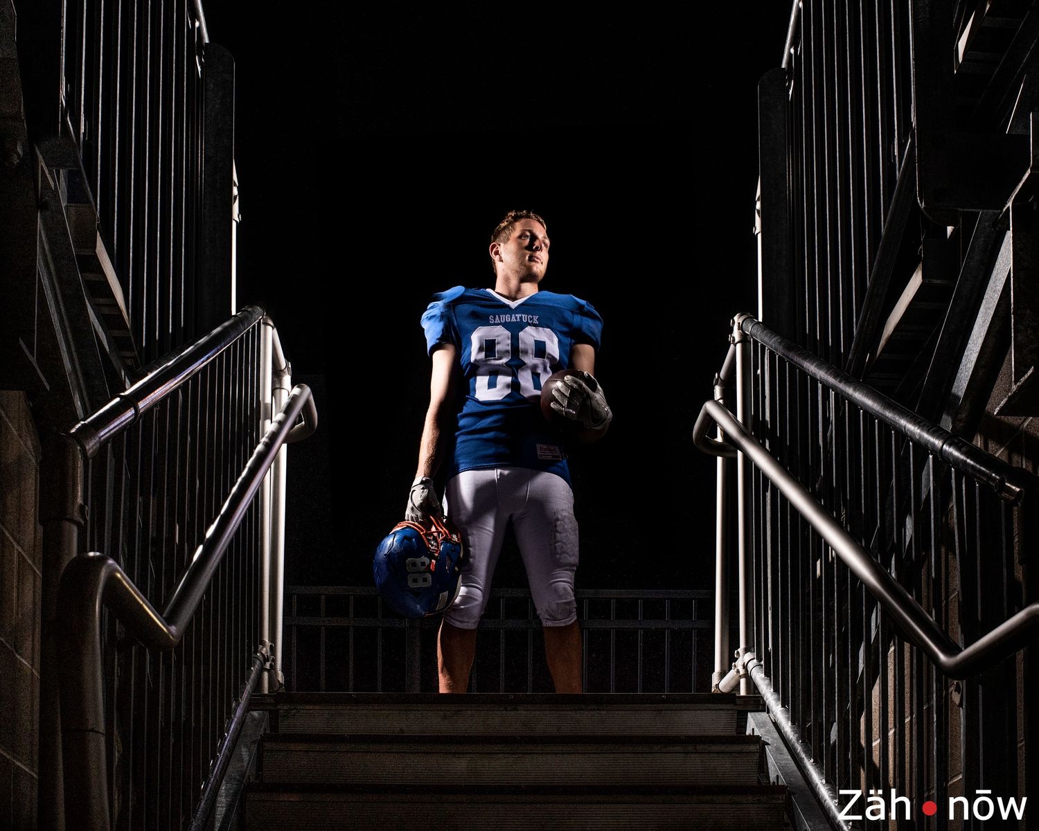 Silhouetted figure in football uniform performs dramatic poses against dark background.