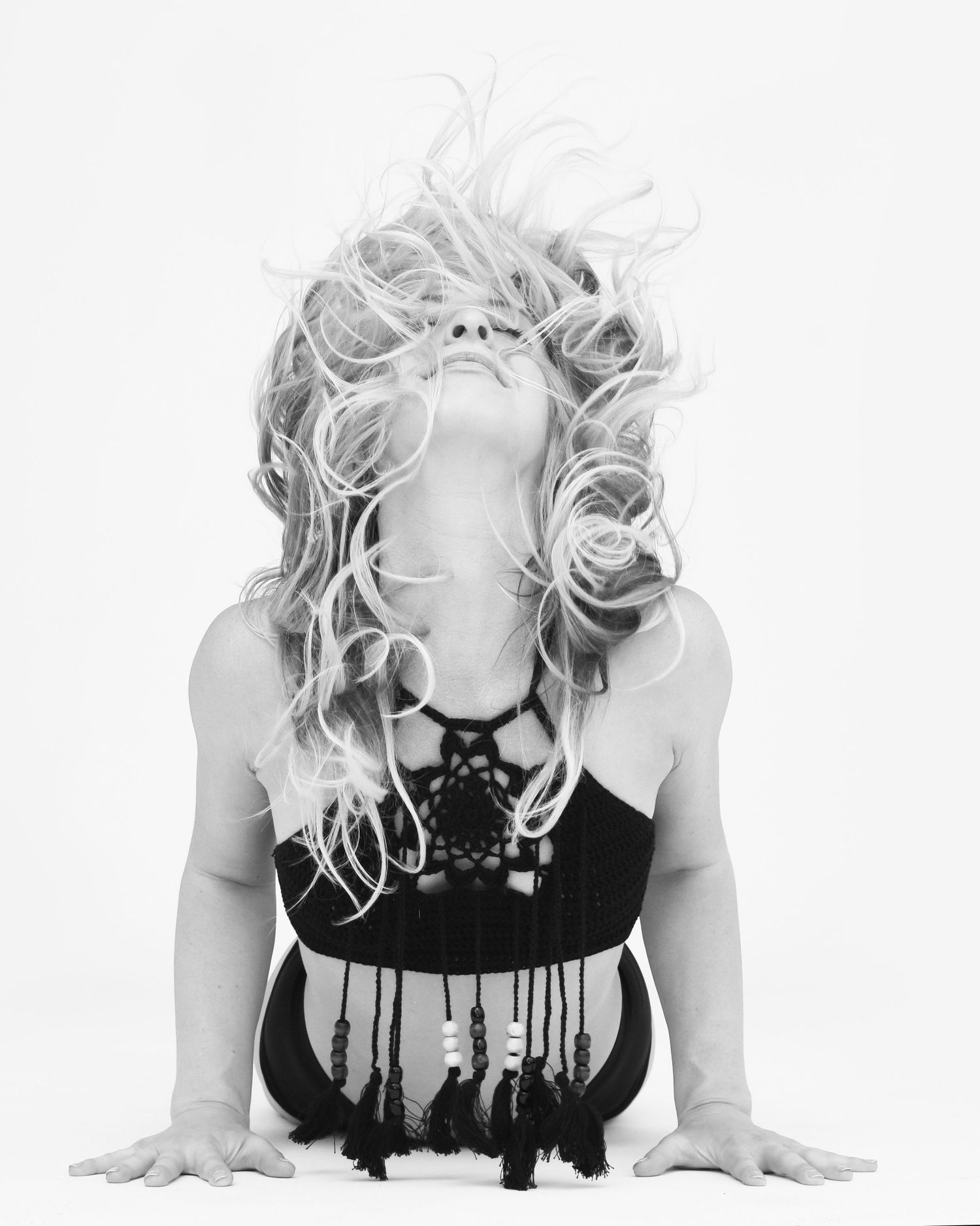 Dramatic floor pose with hair motion captured in artistic black and white photography.