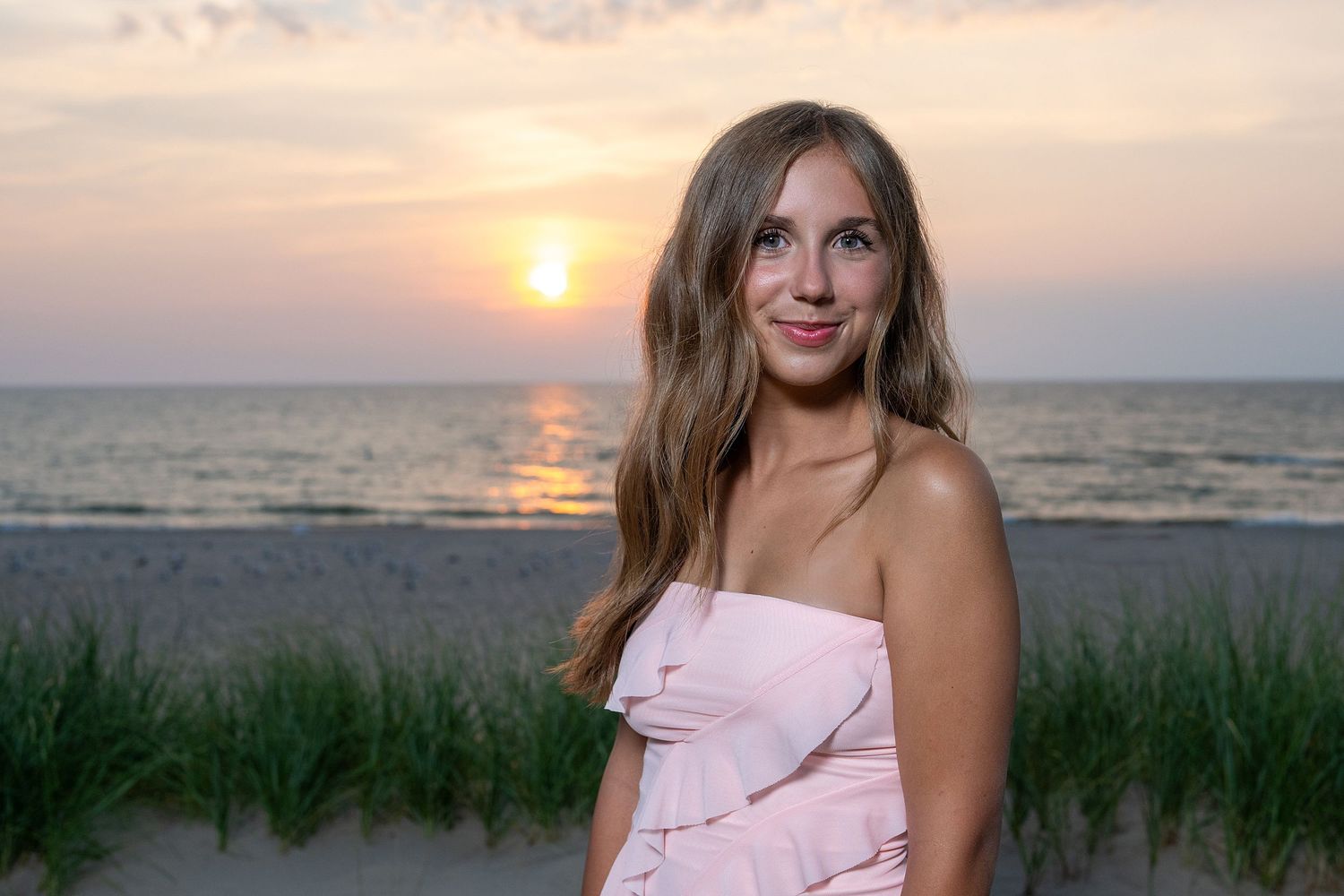 Beachside portrait during sunset with ocean waves in background.