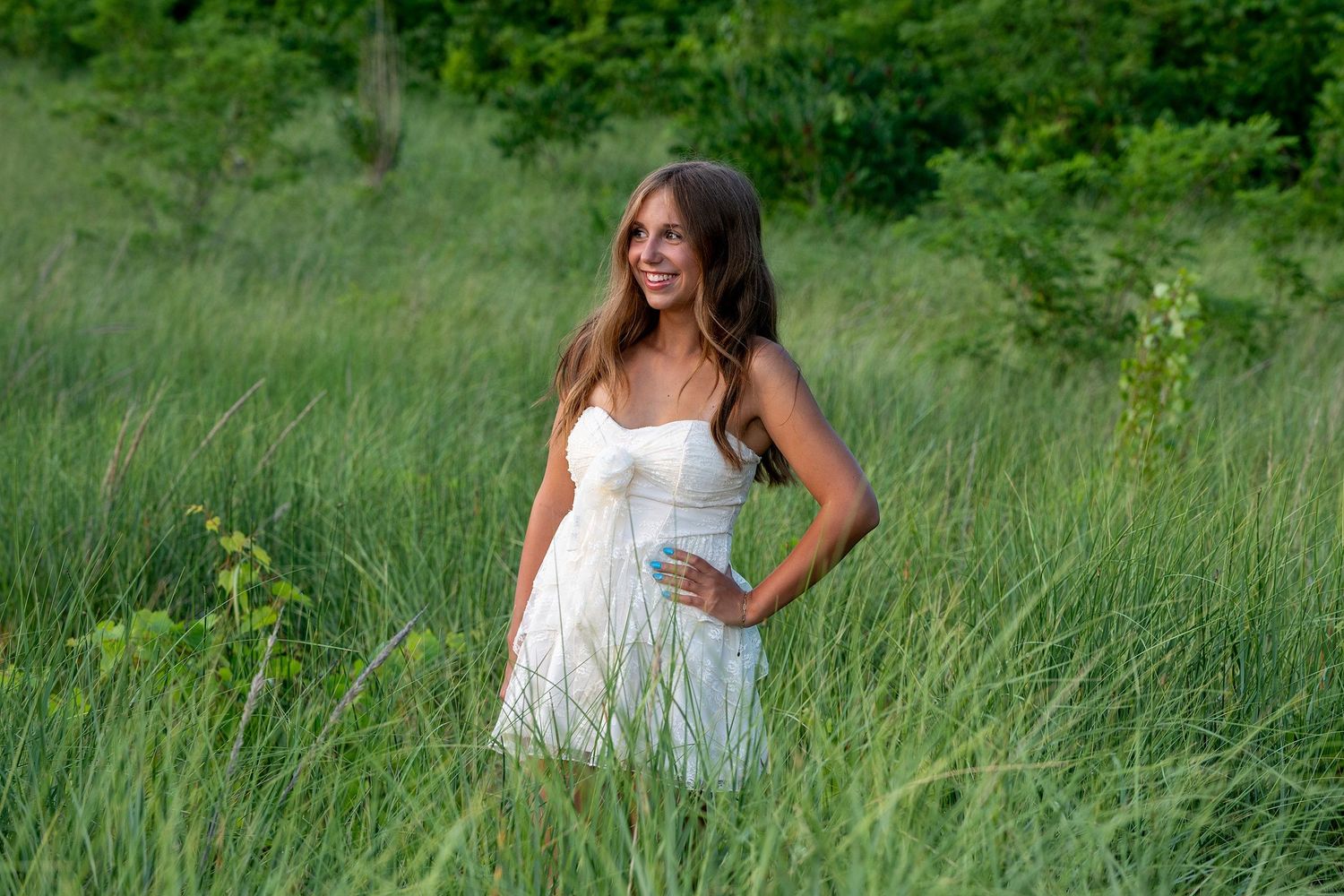 White summer dress contrasting against lush green meadow grass.