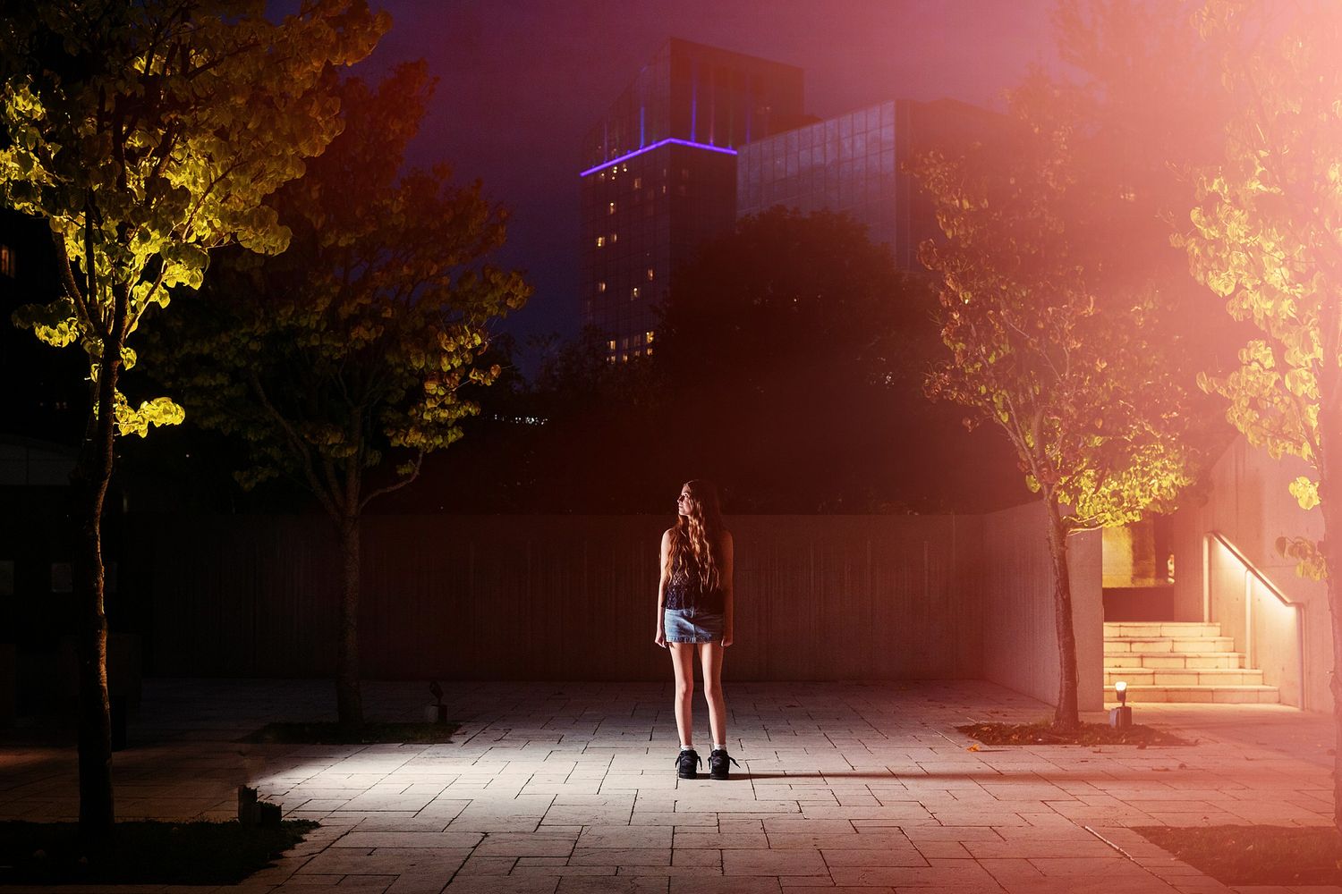 Sunset creates a warm glow over an urban street scene with dramatic lighting and shadows.