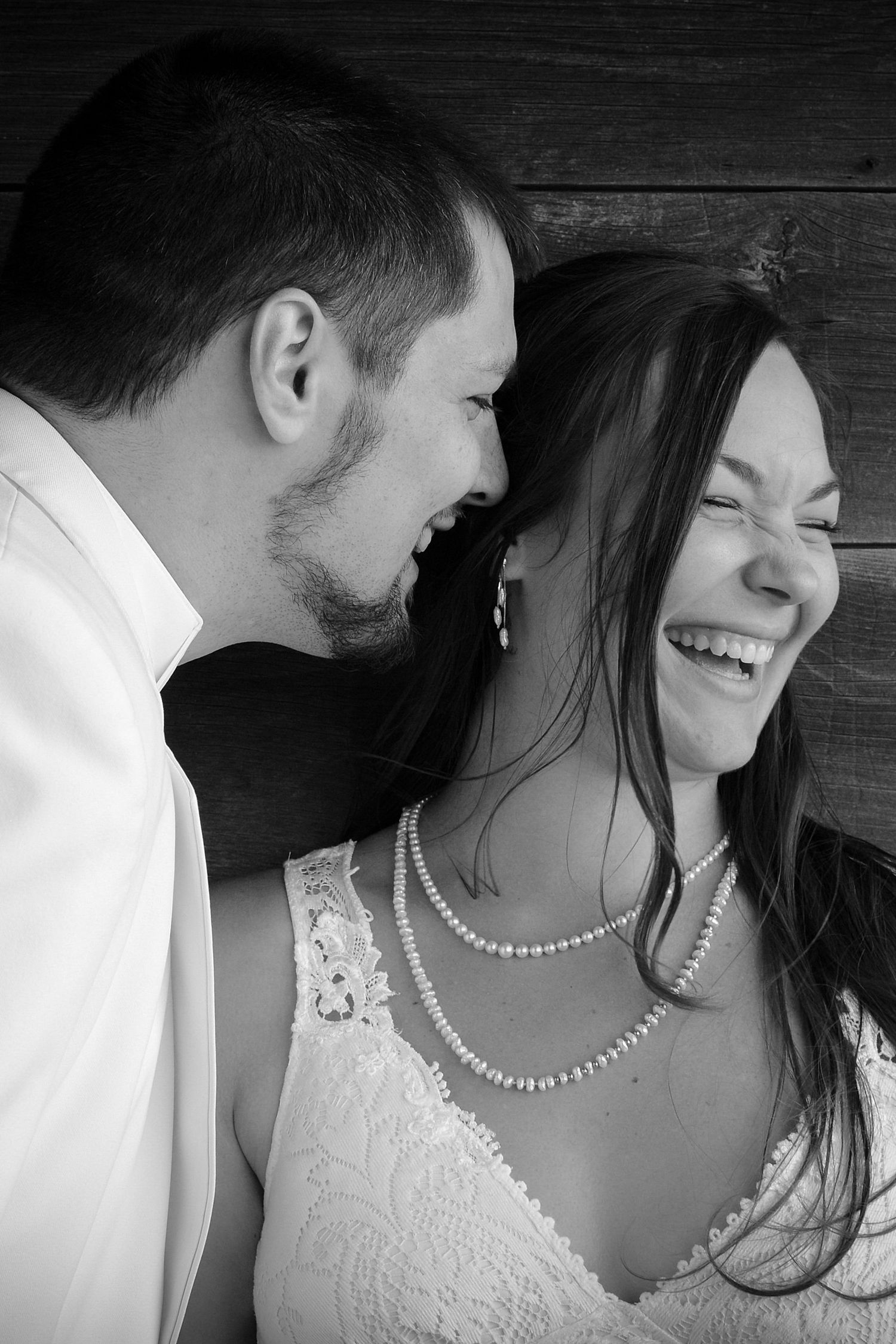 Intimate black and white portrait showing pearl necklace and lace wedding dress details.