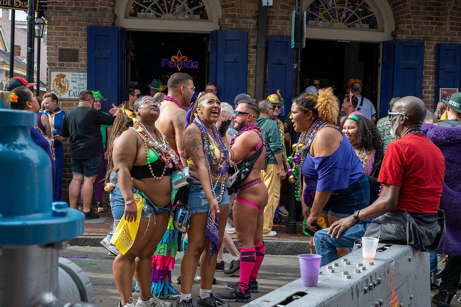 Street festival scene with crowds gathering along historic brick buildings.