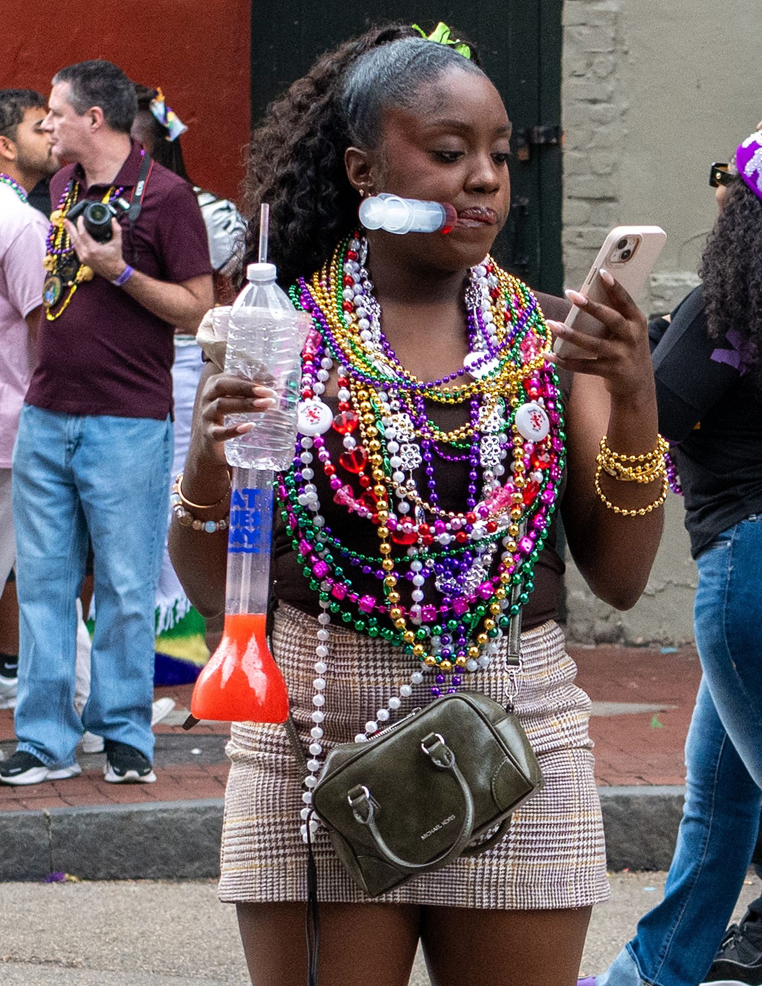 Partygoers adorned with colorful Mardi Gras beads enjoying celebrations in the French Quarter.