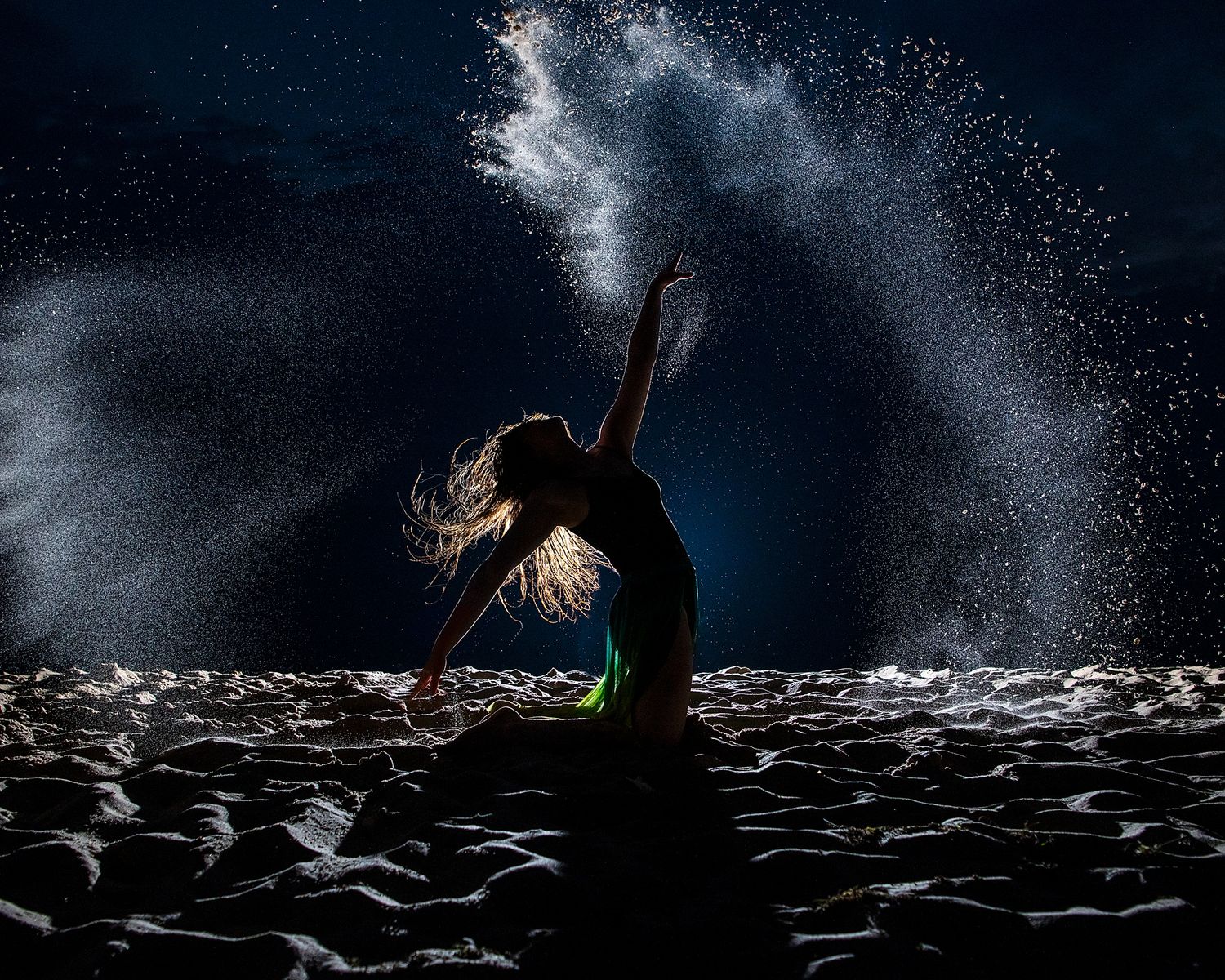 Dark silhouettes against dramatic water spray and mist effects in theater audience.