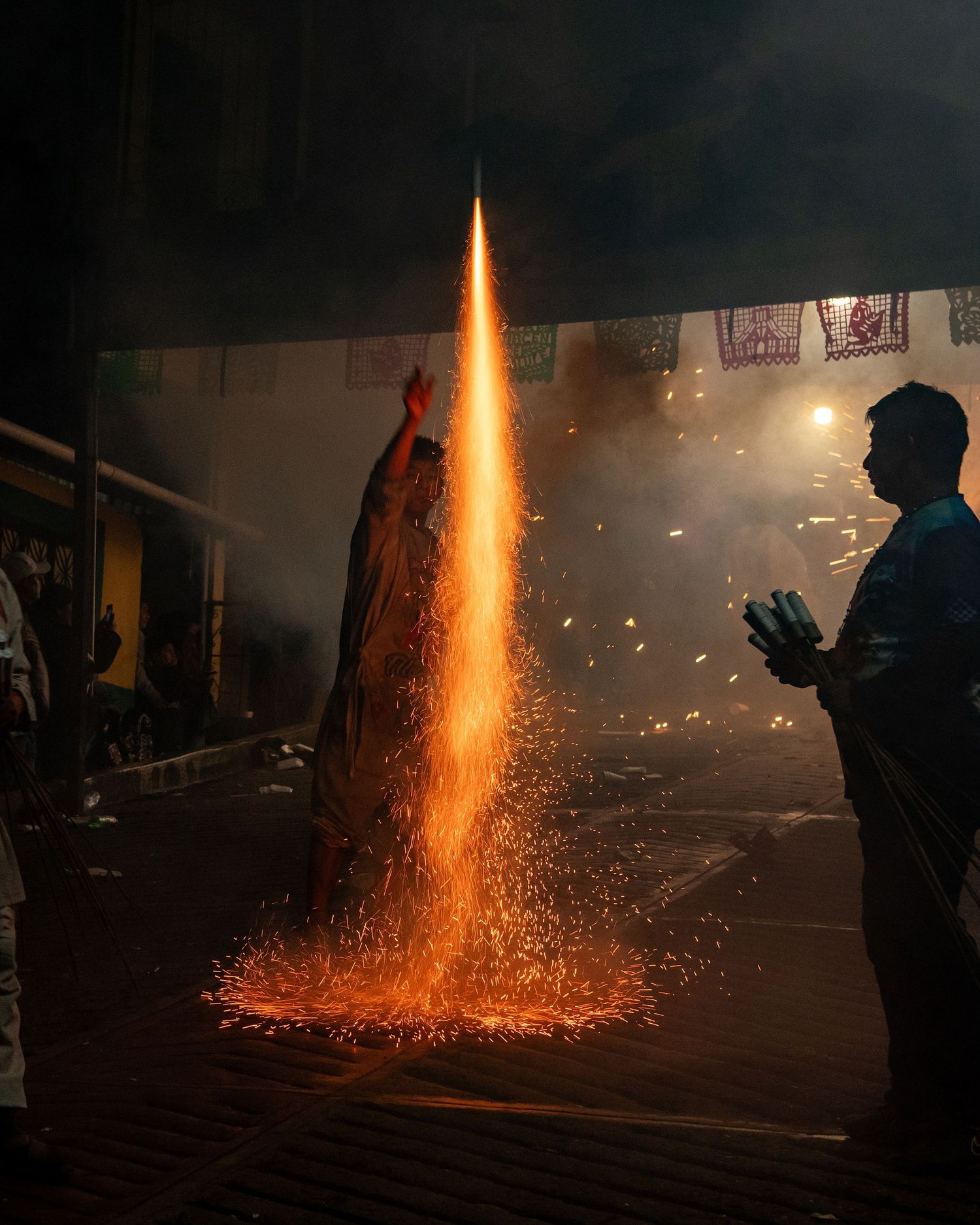 Bright firework fountains shooting sparks into the dark night sky.