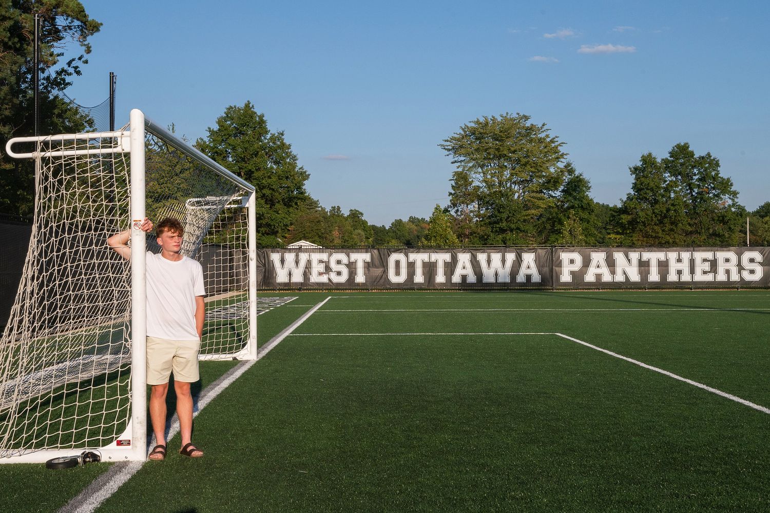 A soccer field with goal post and West Ottawa Panthers text visible in the background.