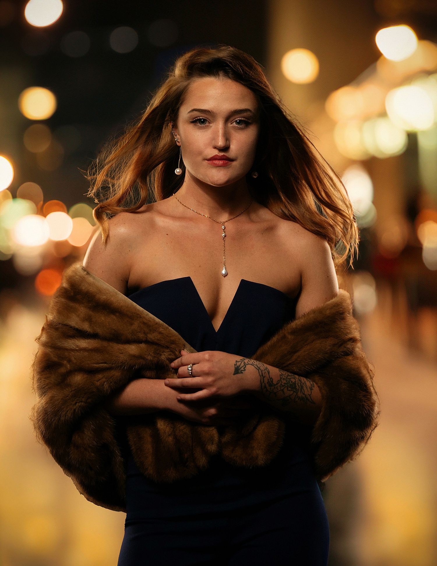 Glamorous evening portrait with fur wrap and bokeh lights.