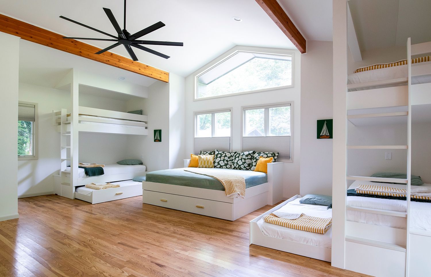 Bright loft space with exposed wooden beams, skylights, and hardwood floors.