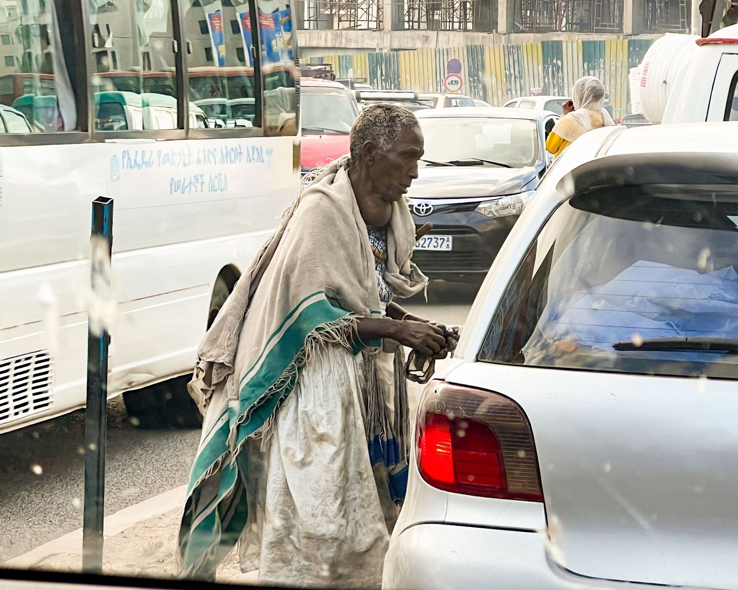Cars parked along a street with a person walking past them.