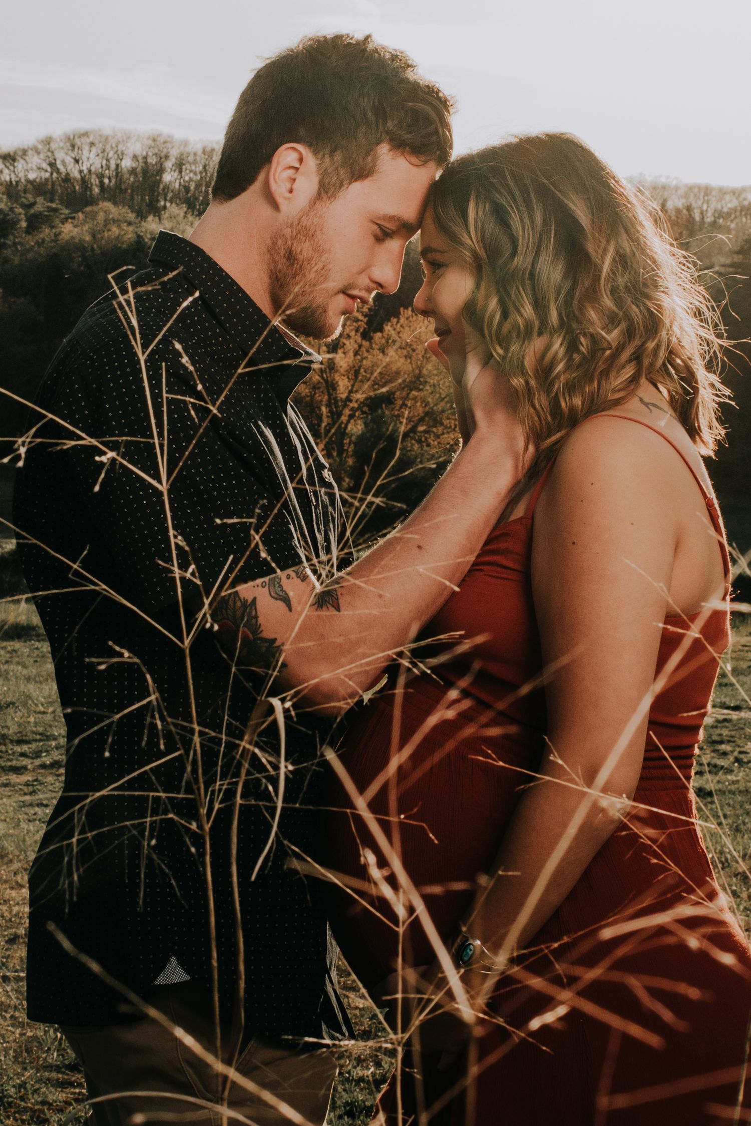 Intimate couple portrait session at sunset with warm lighting and natural scenery.