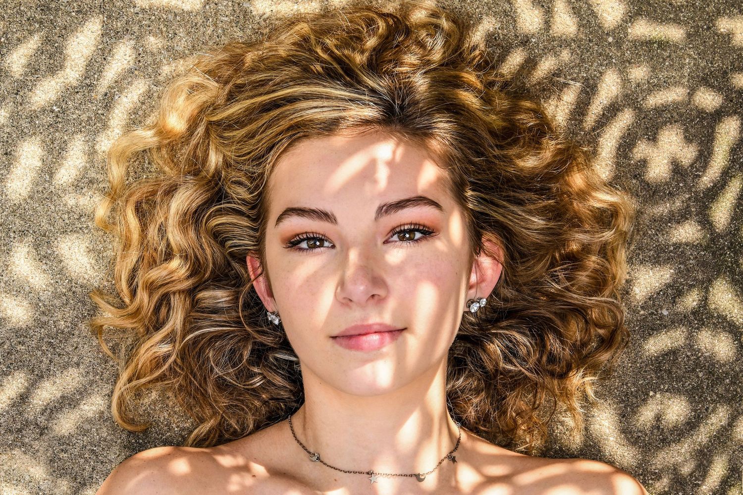 Close-up portrait series with natural lighting and leaf shadow patterns.