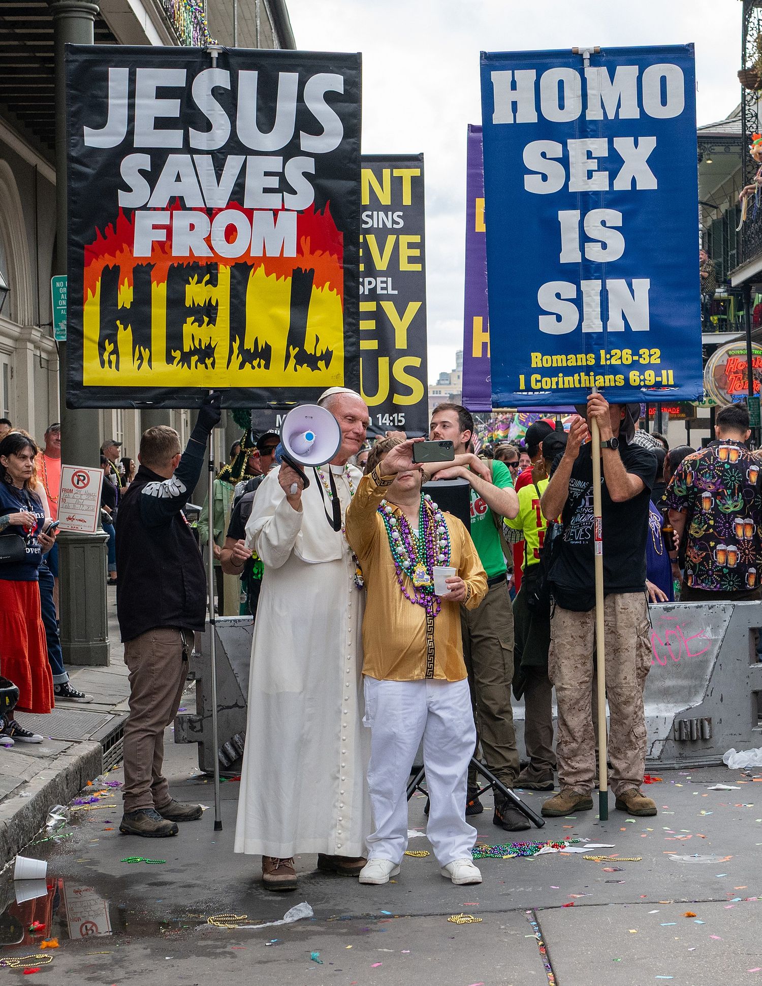 Row of religious protest signs displayed along a city street.