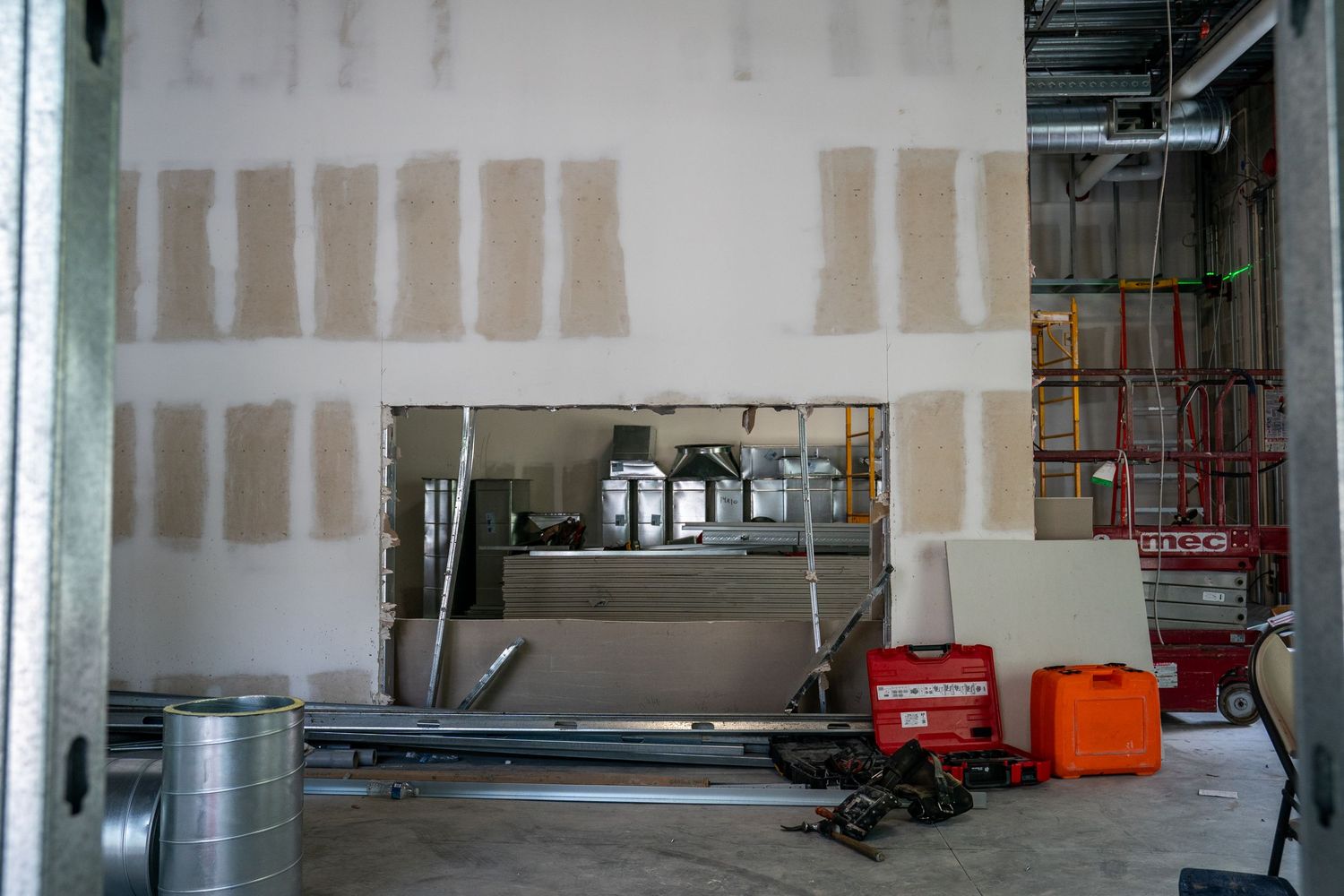 Partially completed interior space showing drywall installation and construction materials.
