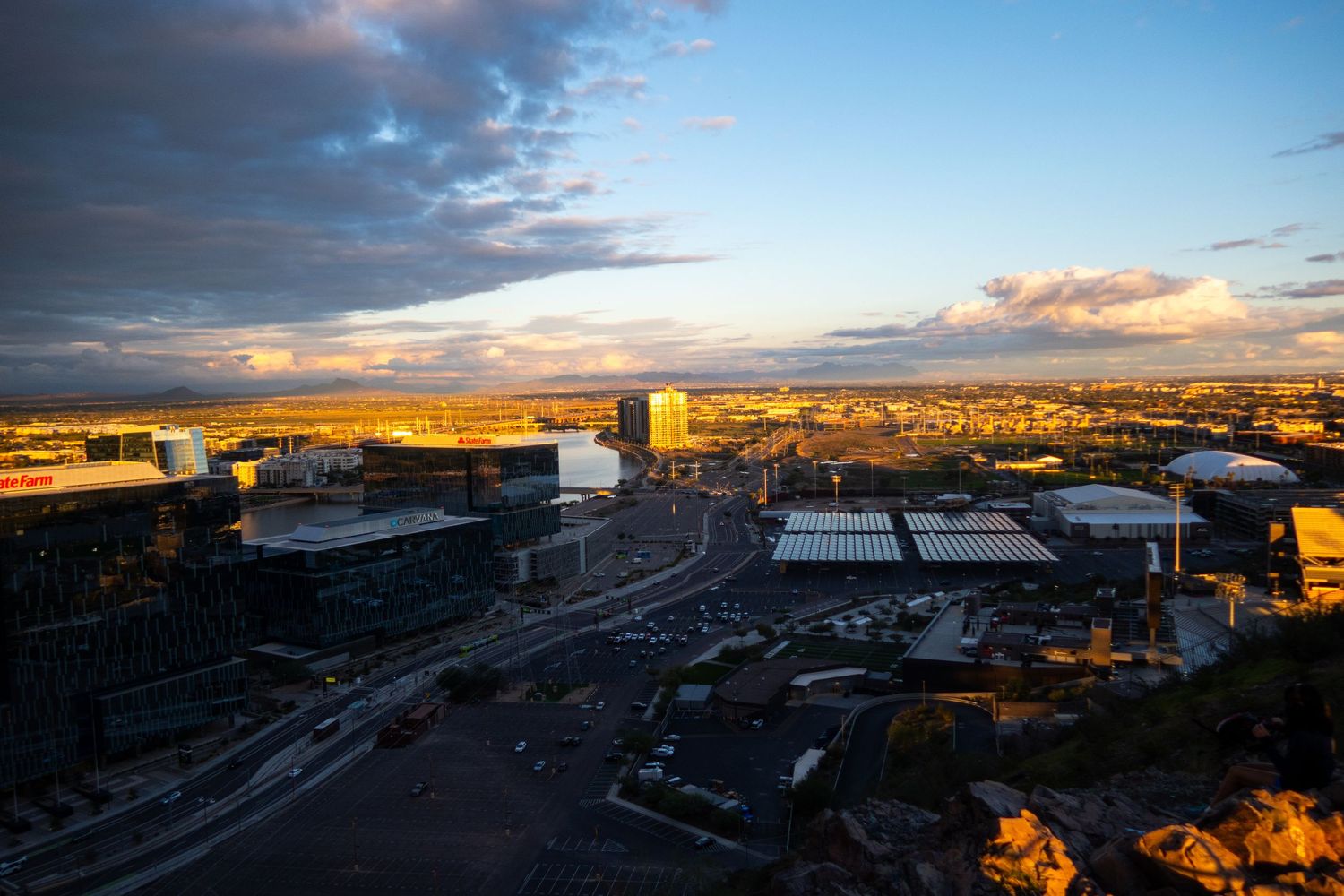 Aerial view of industrial area and city buildings during sunset.
