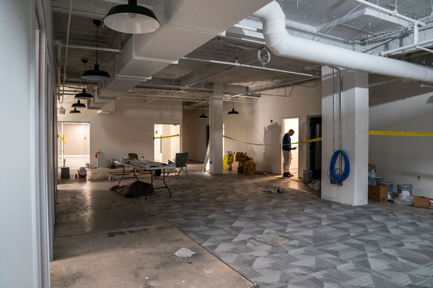 Large unfinished commercial space with concrete floors and exposed ceiling utilities.
