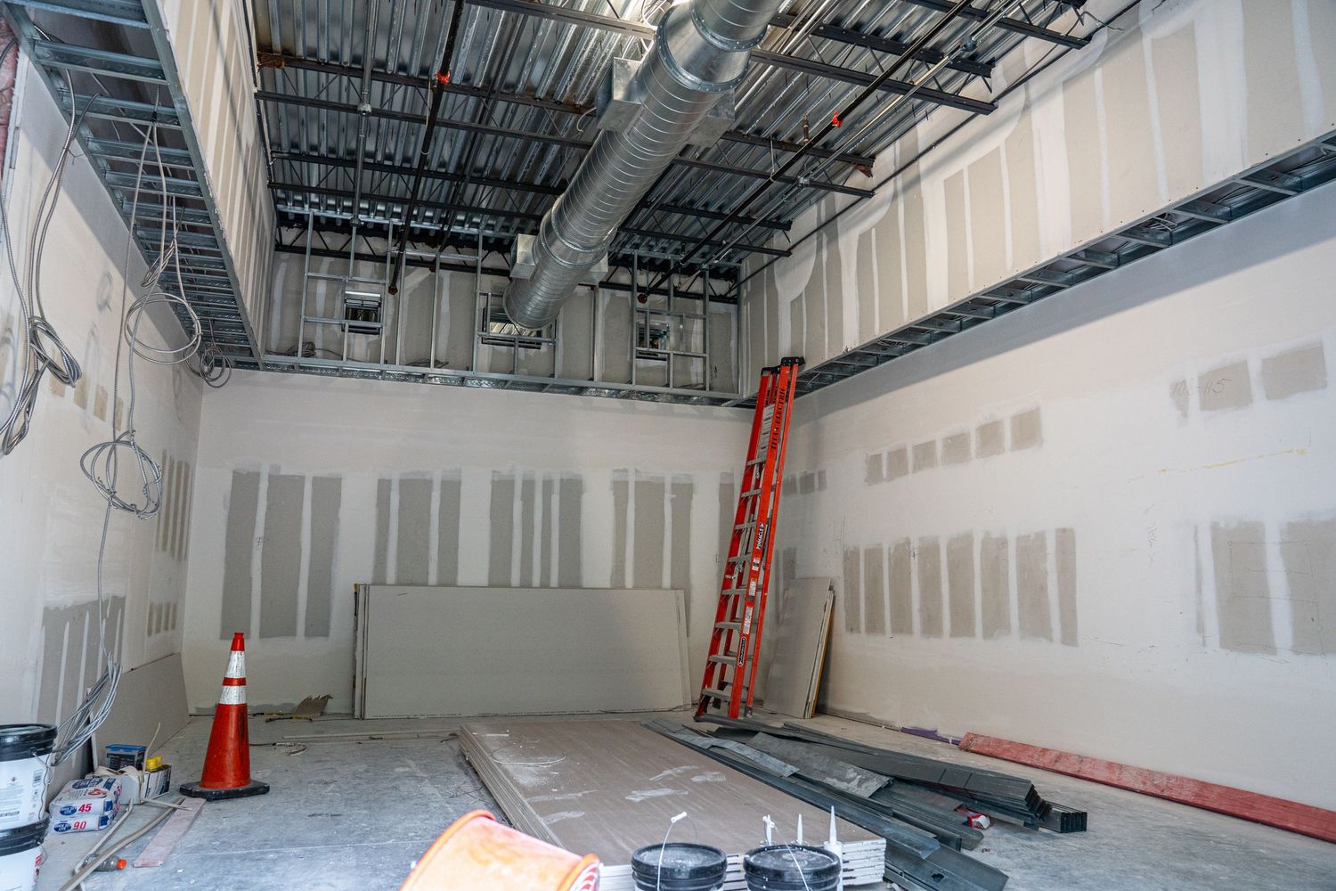 Large open commercial space under construction with natural lighting and exposed utilities.