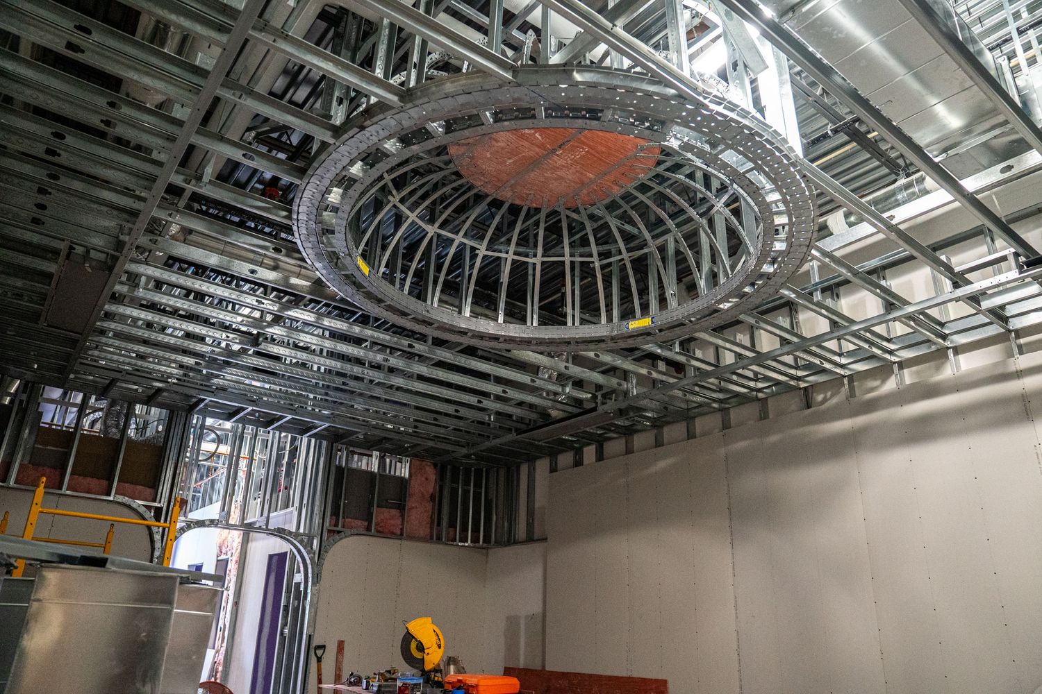 Circular architectural detail in commercial ceiling with exposed metal framework and ductwork.