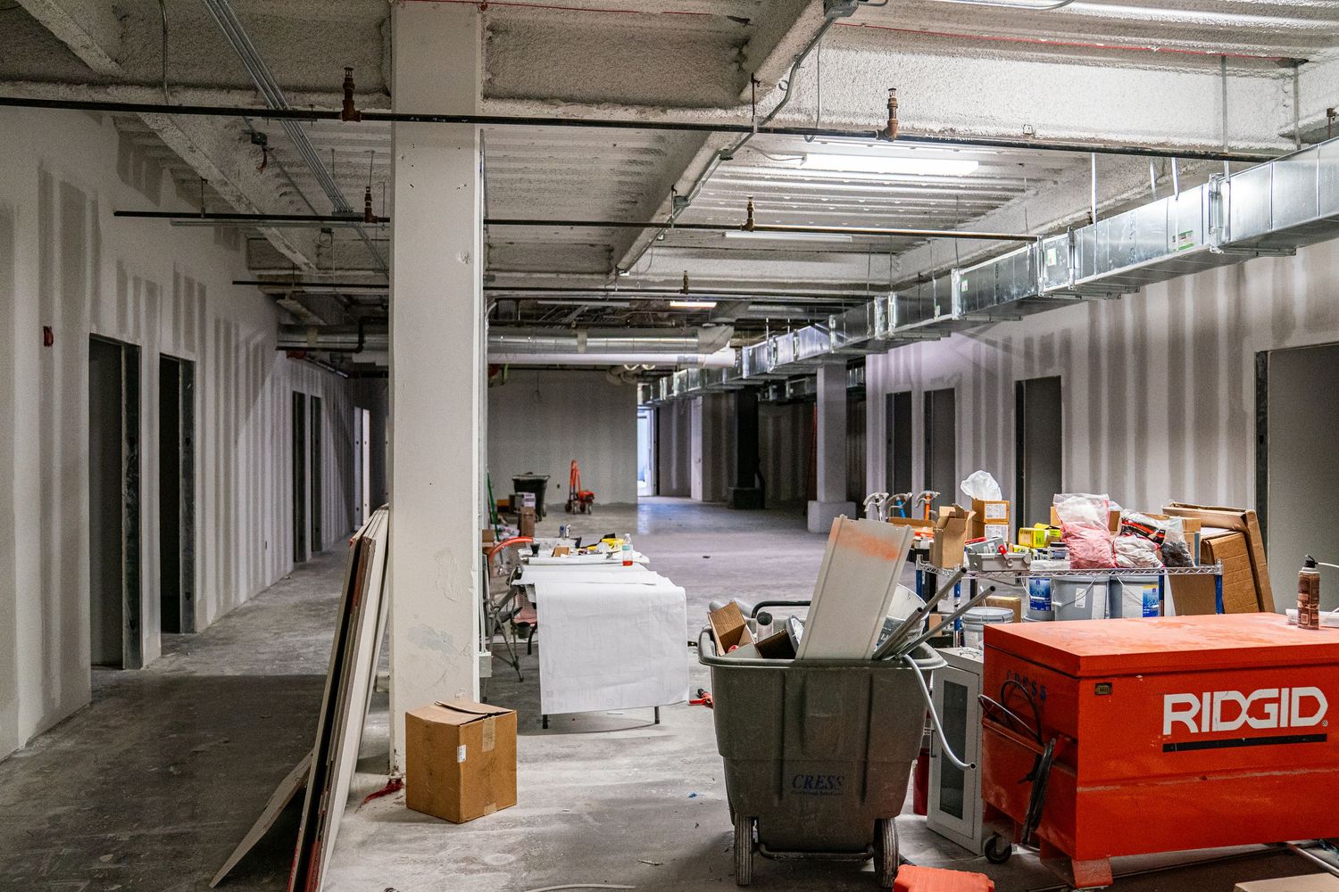 Industrial space under renovation with exposed ceiling and construction materials.